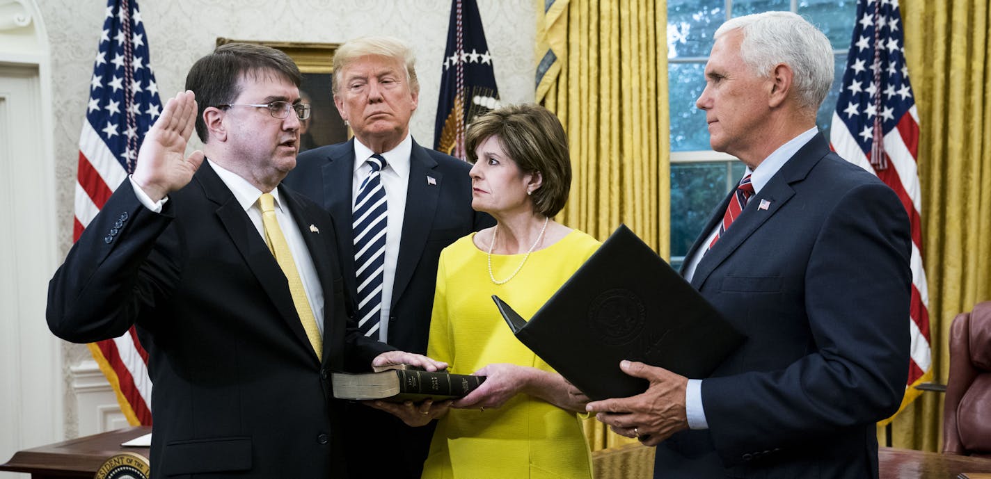 President Donald Trump watches as Vice President Mike Pence swears in Robert Wilkie as the new secretary of the Department of Veterans Affairs in the Oval Office of the White House, July 30, 2018. (Doug Mills/The New York Times)