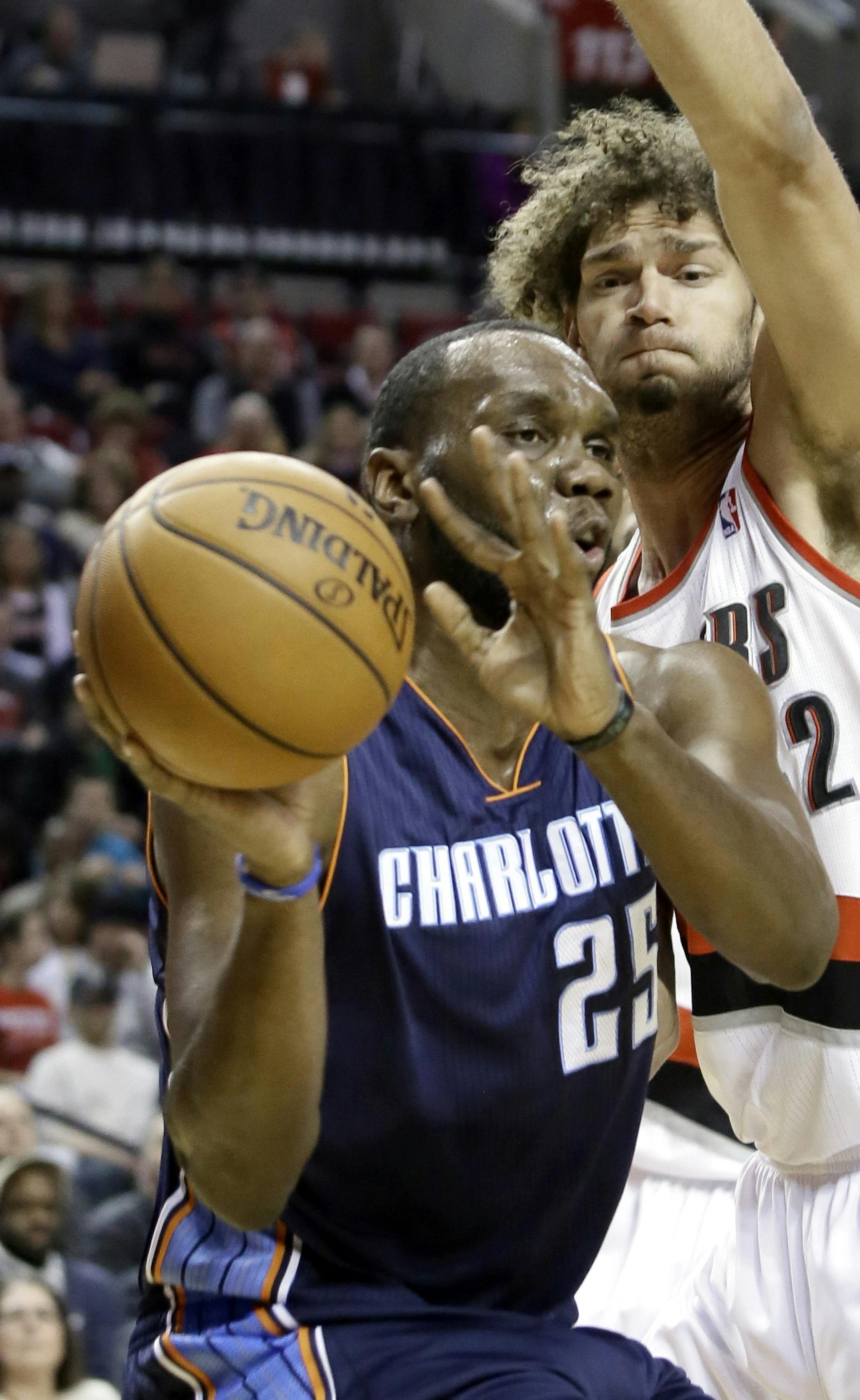 Charlotte Bobcats center Al Jefferson, left, passes off as Portland Trails Blazers center Robin Lopez defends during the first half of an NBA basketball game in Portland, Ore., Thursday, Jan. 2, 2014. (AP Photo/Don Ryan)
