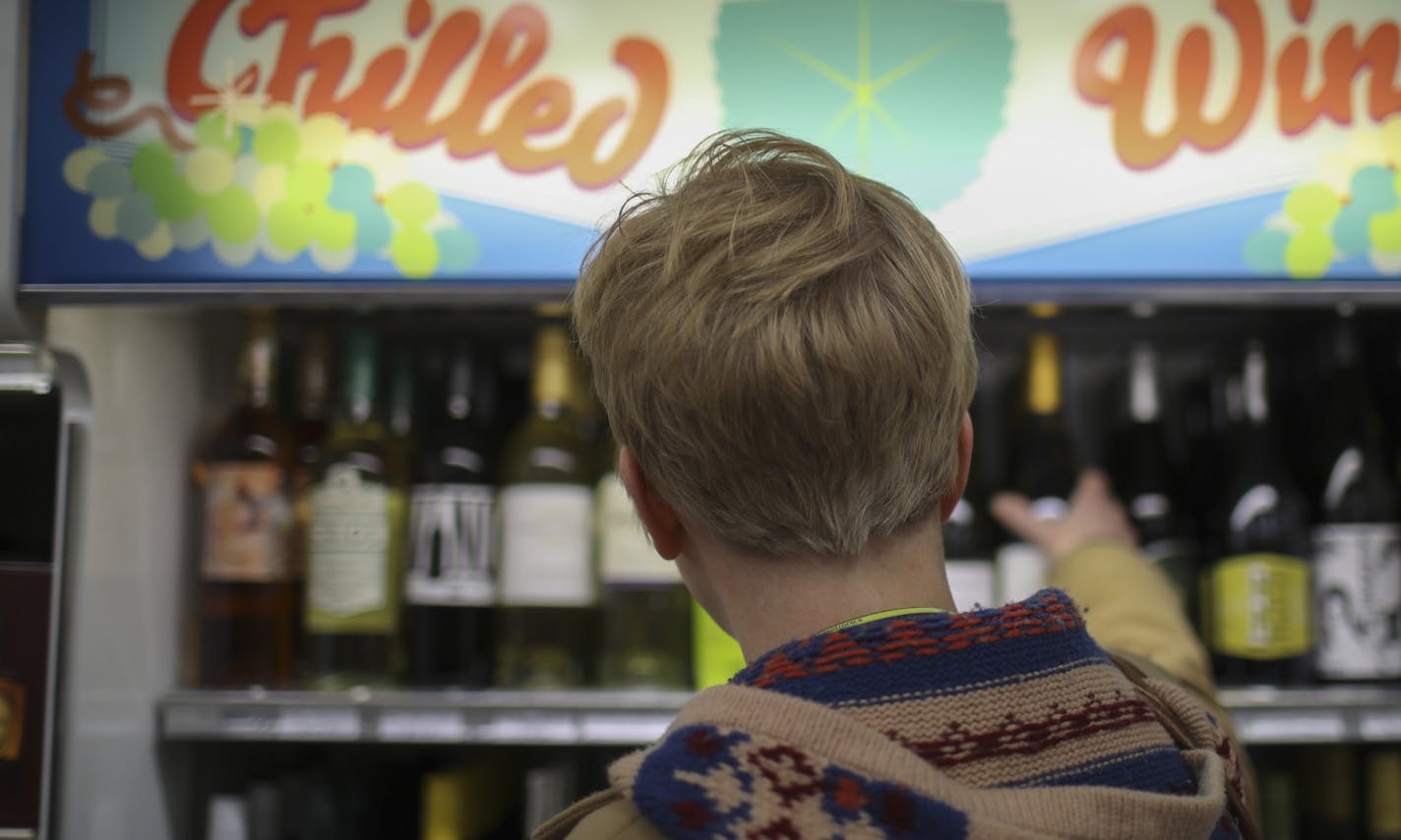 A woman grabbed a bottle of wine from the shelf at Surdyk's in Northeast Minneapolis Tuesday afternoon. ] JEFF WHEELER &#xef; jeff.wheeler@startribune.com Gov. Mark Dayton signed the Sunday liquor sales bill into law today, Tuesday, March 7, 2017. At Surdyk's Liquor & Cheese Shop in Northeast Minneapolis, shoppers were pleased with the development.