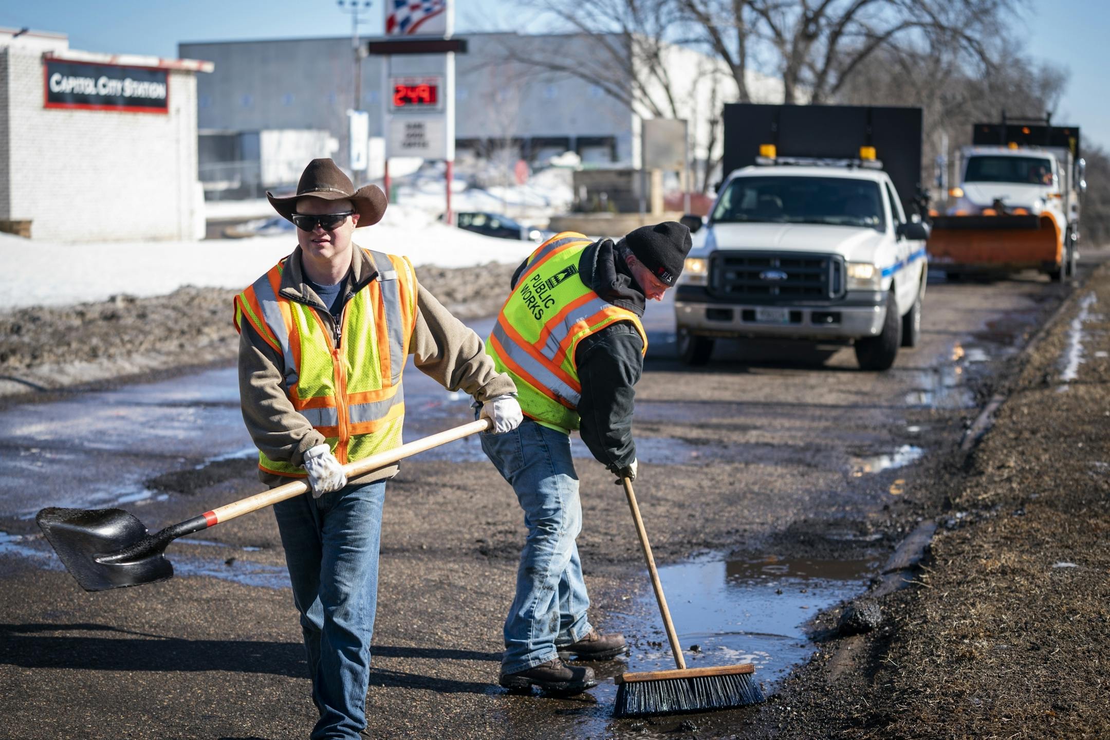 Street service workers Bradley Therres, from left, and Lance Hamby fill potholes on Shepard Road.