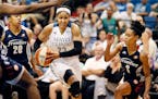 Connecticut Sun defenders Alex Bentley left and Jasmine Thomas put pressure on Maya Moore as she drove to the basket at Target Center on Wednesday.