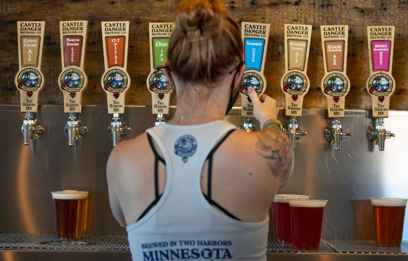 Castle Danger Brewery taproom assistant Jenn Zimmerman poured beers for a group of customers .