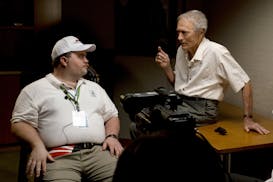 In this image released by Warner Bros. Pictures, director Clint Eastwood speaks with actor Paul Walter Hauser as they work during the filming of the m