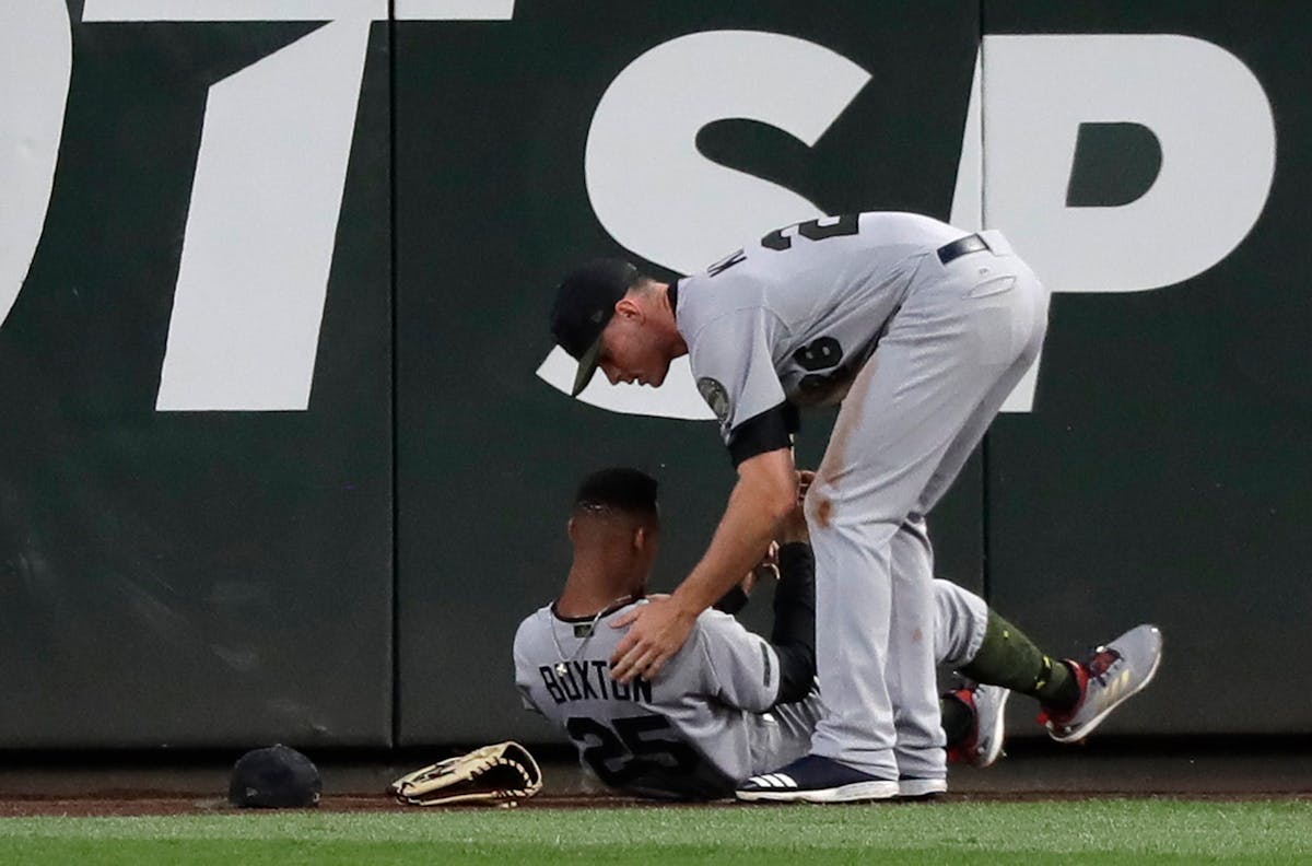 Twins center fielder Byron Buxton (left, being checked by right fielder Max Kepler after Buxton ran into the outfield wall May 26 in Seattle) was rein