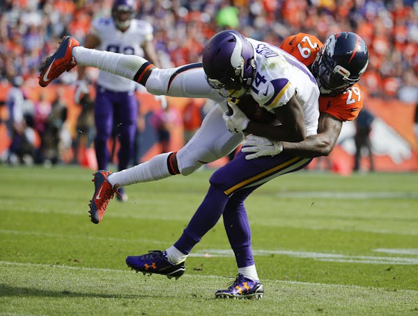 Denver Broncos cornerback Bradley Roby, right, tackles Minnesota Vikings wide receiver Stefon Diggs during the first half of an NFL football game, Sun