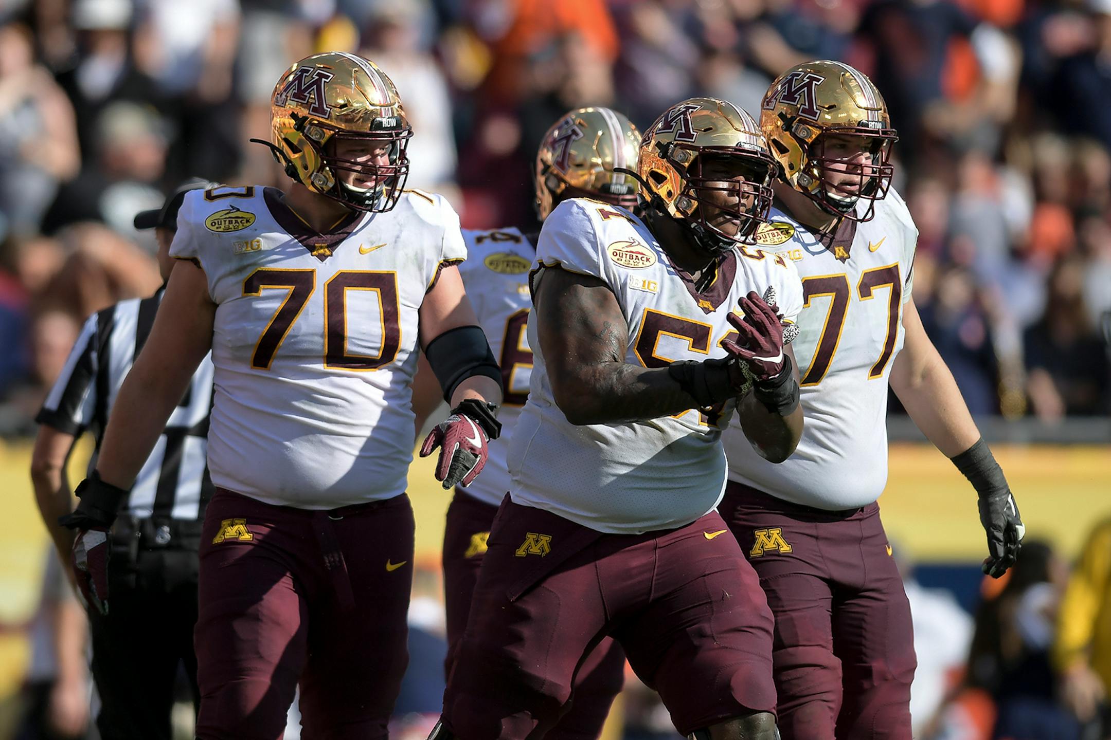 Minnesota Gophers offensive lineman Curtis Dunlap Jr. (51) celebrated alongside offensive lineman Sam Schlueter (70) and offensive lineman Blaise Andries (77) after a touchdown against the Auburn Tigers in the second quarter.