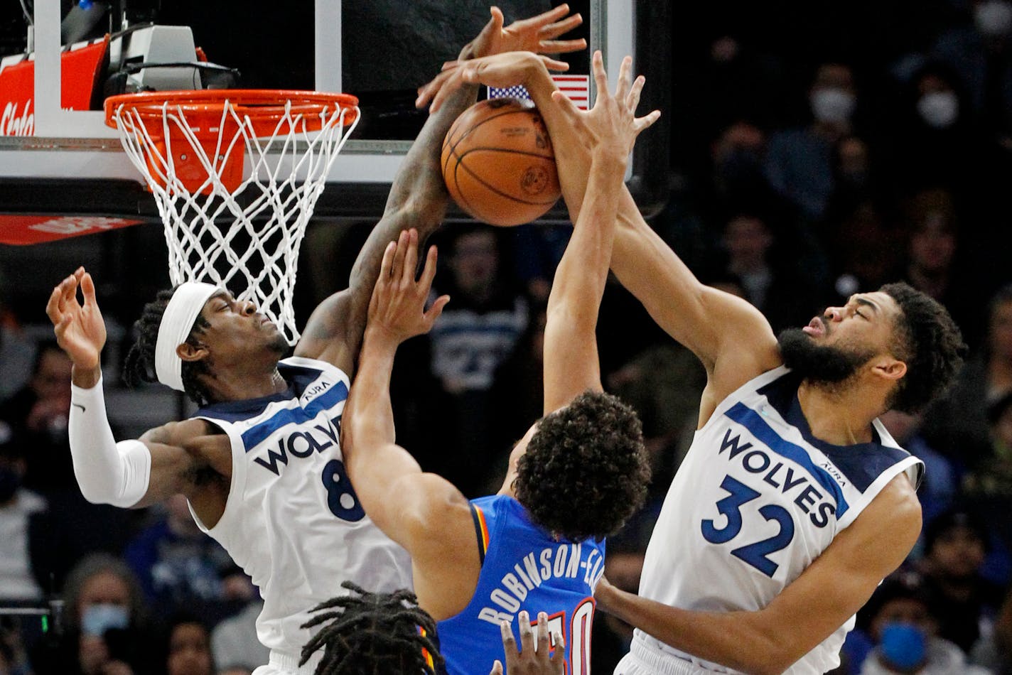 Oklahoma City center Jeremiah Robinson-Earl tries to go to the basket as Timberwolves forward Jarred Vanderbilt and center Karl-Anthony Towns defend in the first quarter