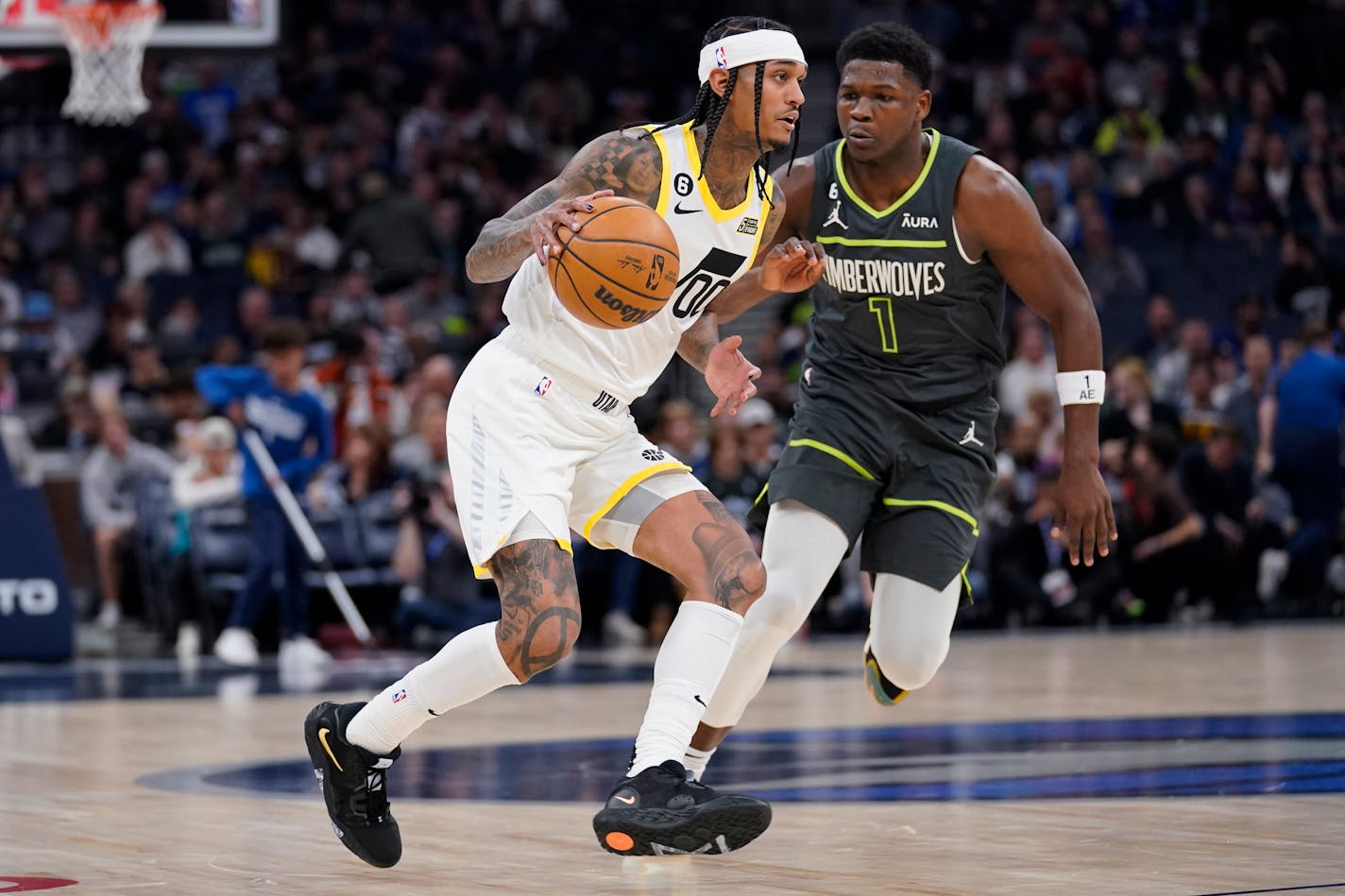 Utah Jazz guard Jordan Clarkson (00) is defended by Minnesota Timberwolves forward Anthony Edwards (1) during the first half of an NBA basketball game, Friday, Oct. 21, 2022, in Minneapolis. (AP Photo/Abbie Parr)