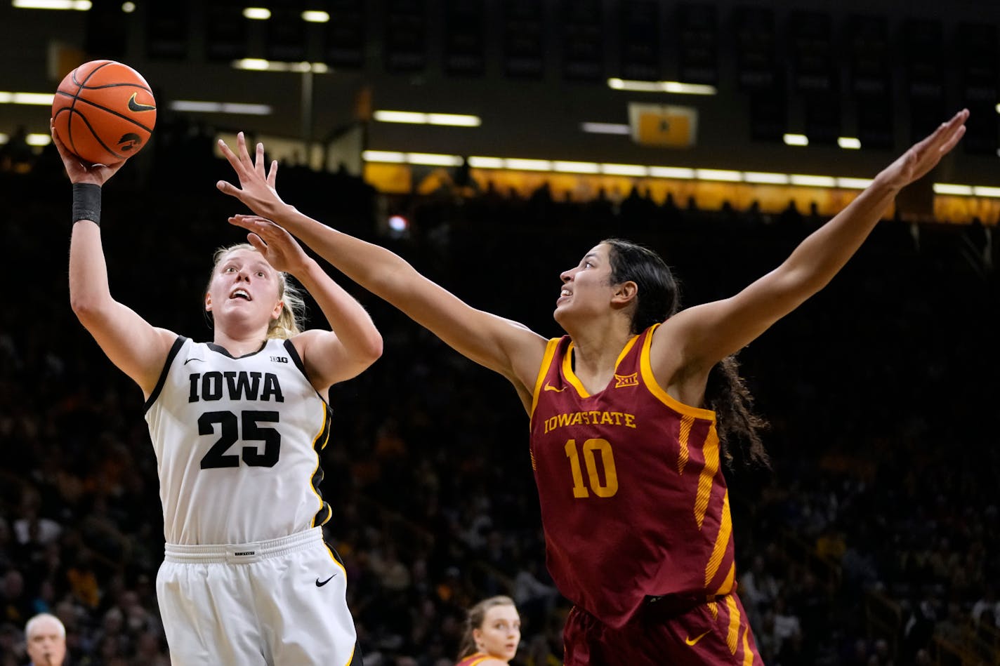 Iowa forward Monika Czinano (25) drives to the basket past Iowa State center Stephanie Soares (10) during the second half of an NCAA college basketball game, Wednesday, Dec. 7, 2022, in Iowa City, Iowa. Iowa won 70-57. (AP Photo/Charlie Neibergall)