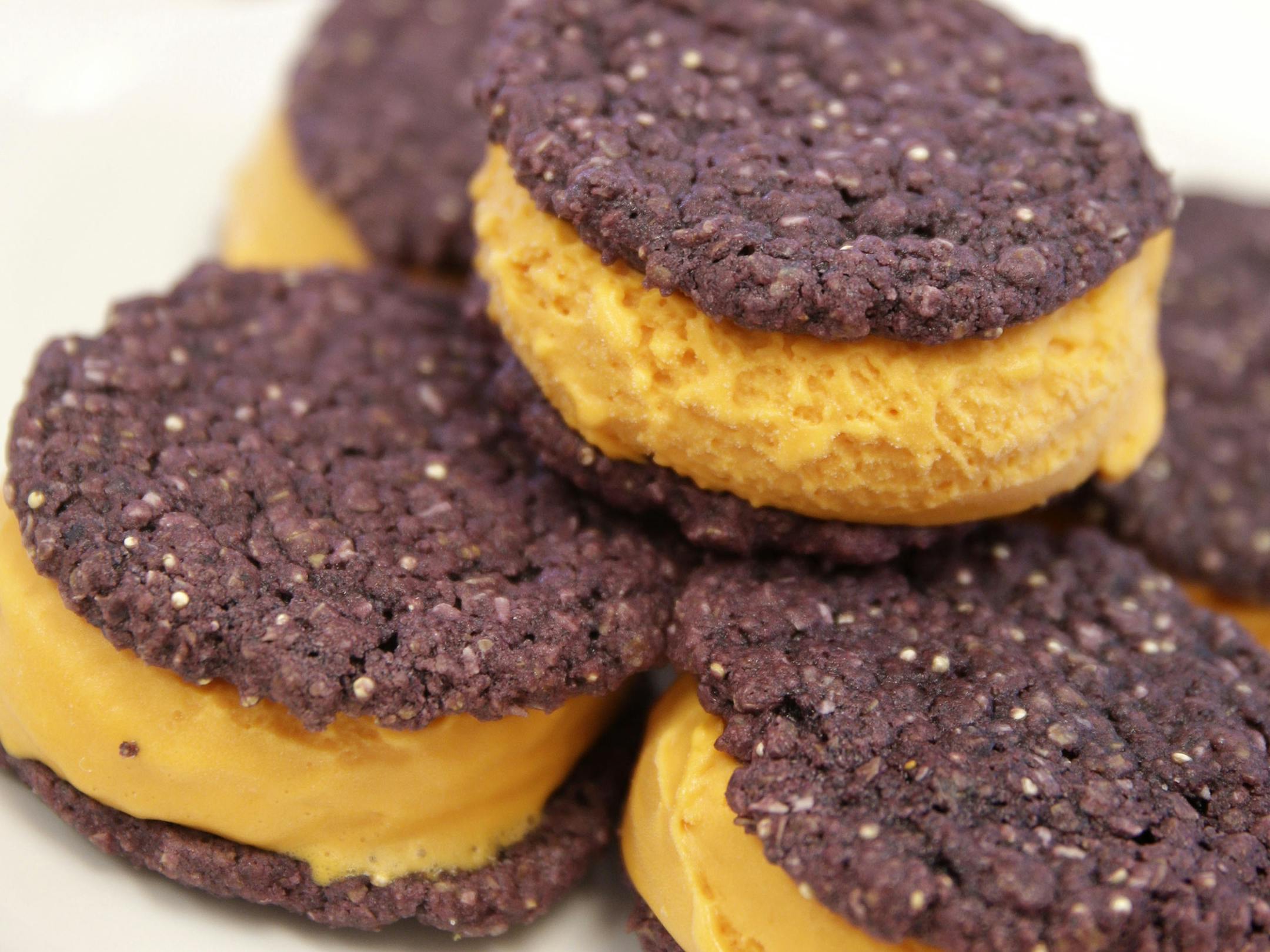 In this photo from July 29, 2015, a sandwich of corn ice cream and oatmeal cookies, colored with extracts from plants, is served at the GNT offices in Tarrytown, N.Y. Several major food makers are hoping to win over customers by vowing to rid their products of artificial ingredients. But replicating the vivid colors Americans have to expect without synthetic dyes presents technical and regulatory challenges, and in some cases will mean new hues for popular products. (AP Photo/Seth Wenig)