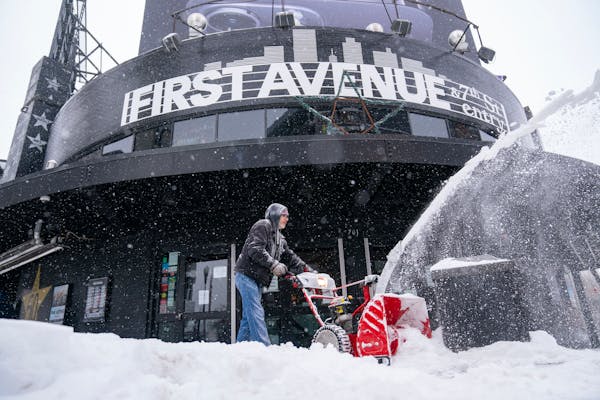Bryan Erickson clears snow in front of First Avenue Thursday in Minneapolis.