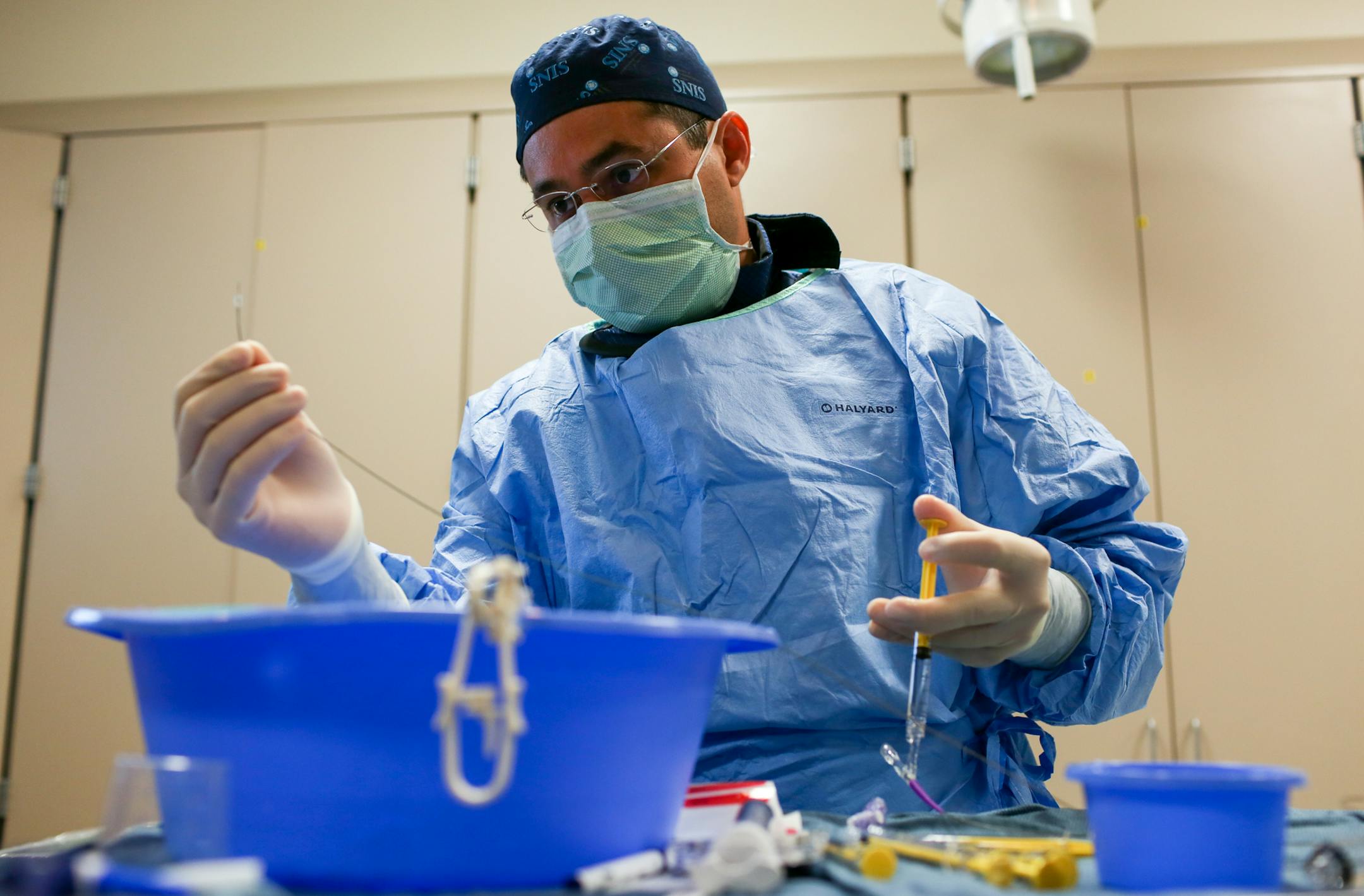Neurointerventional Radiologist Dr. Josser Delgado, MD looks at the balloon catheter which will be used for preventive surgery on a brain aneurysm, at Abbott Northwestern Hospital, on Tuesday morning. ] COURTNEY PEDROZA • courtney.pedroza@startribune.com June 13, 2017 Minneapolis, MN Abbott Northwestern Hospital; performed by Dr. Josser Delgado, MD; patient Terri Hopp; preventive surgery on a brain aneurysm