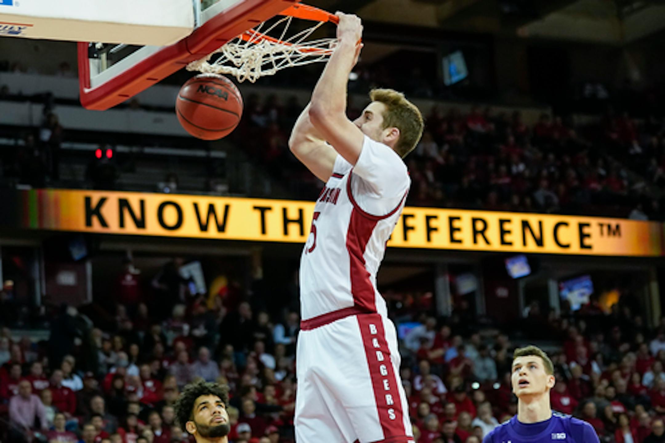 Wisconsin's Nate Reuvers (35) dunks past Northwestern's Boo Buie, left, and Robbie Beran during the second half of an NCAA college basketball game Wednesday, March 4, 2020, in Madison, Wis. Reavers had a team-high 11 points in Wisconsin's 63-48 win. (AP Photo/Andy Manis)