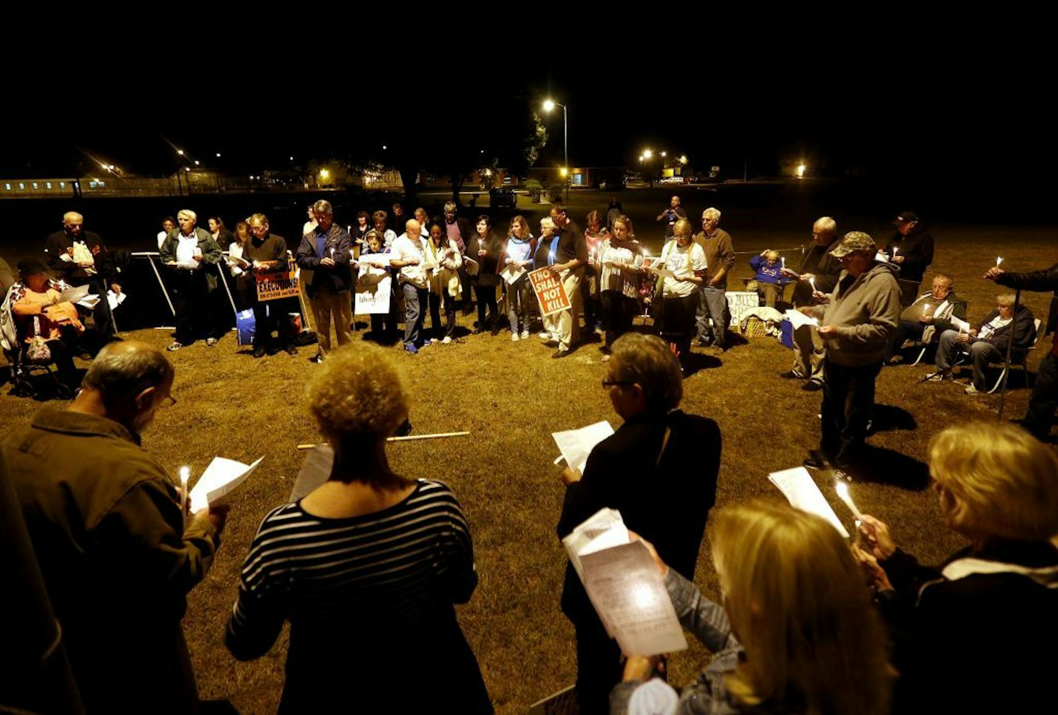 Death penalty opposers stand outside the Florida State Prison while holding candles and singing songs during the execution of Chadwick Banks on Thursday, Nov. 13, 2014, in Raiford, Fla. Banks confessed to the murder of his wife, Cassandra Banks and her daughter Melody Cooper in Quincy, Fla. on Sept. 24, 1992.