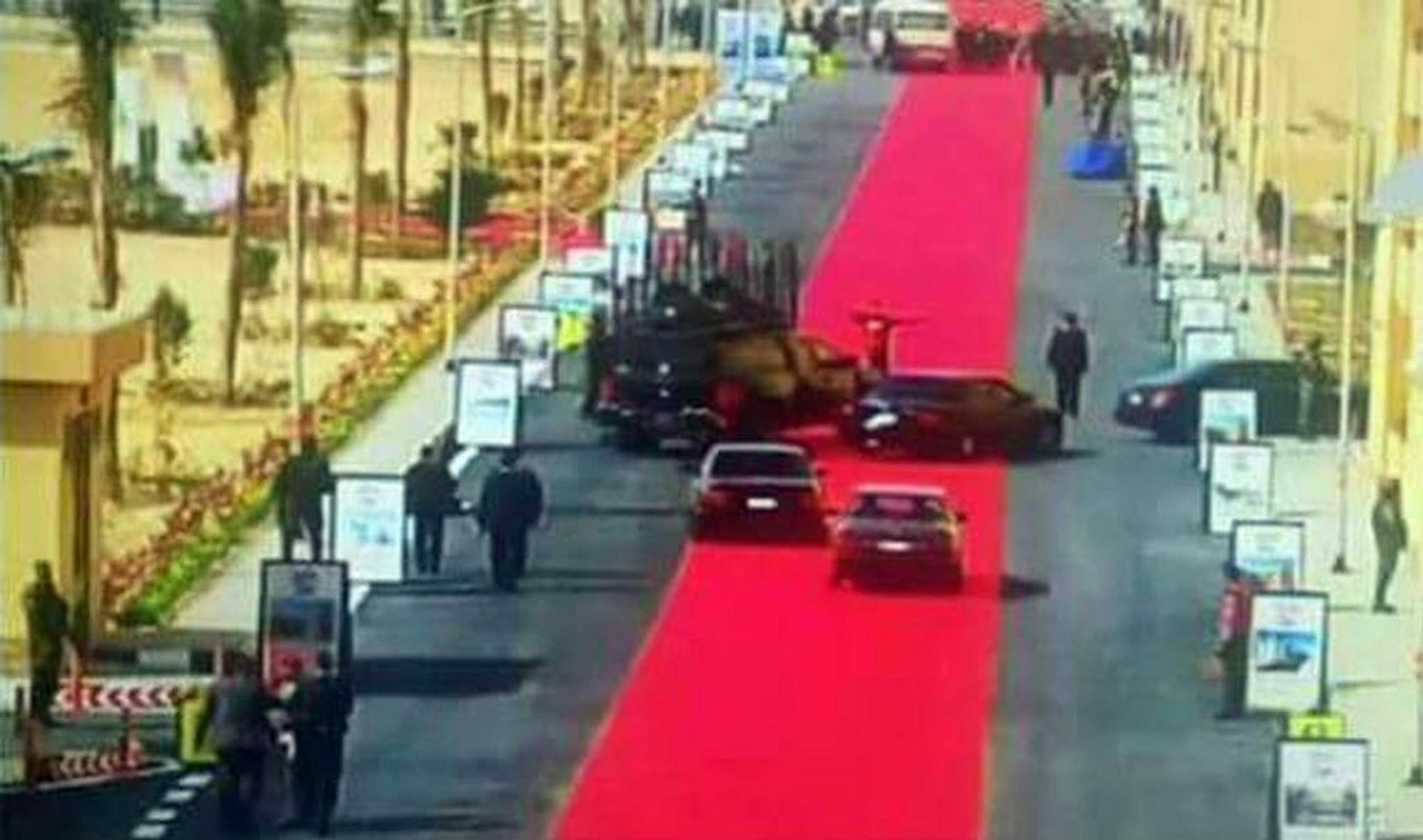 In this Saturday, Feb. 6, 2016 image taken from Egypt State TV, Egyptian President Abdel-Fattah el-Sissi's motorcade drives on a red carpet during a trip to open social housing projects in a suburb of Cairo, Egypt. Images of the giant red carpet prompted a wave of mockery on social media, and one local newspaper devoted its entire front page Monday, Feb. 8, 2016, to accusing el-Sissi of decadence while he asks Egyptians to tighten their belts.