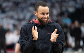 Golden State star Stephen Curry encourages his teammates during a timeout in the first quarter against the Wolves at Target Center.