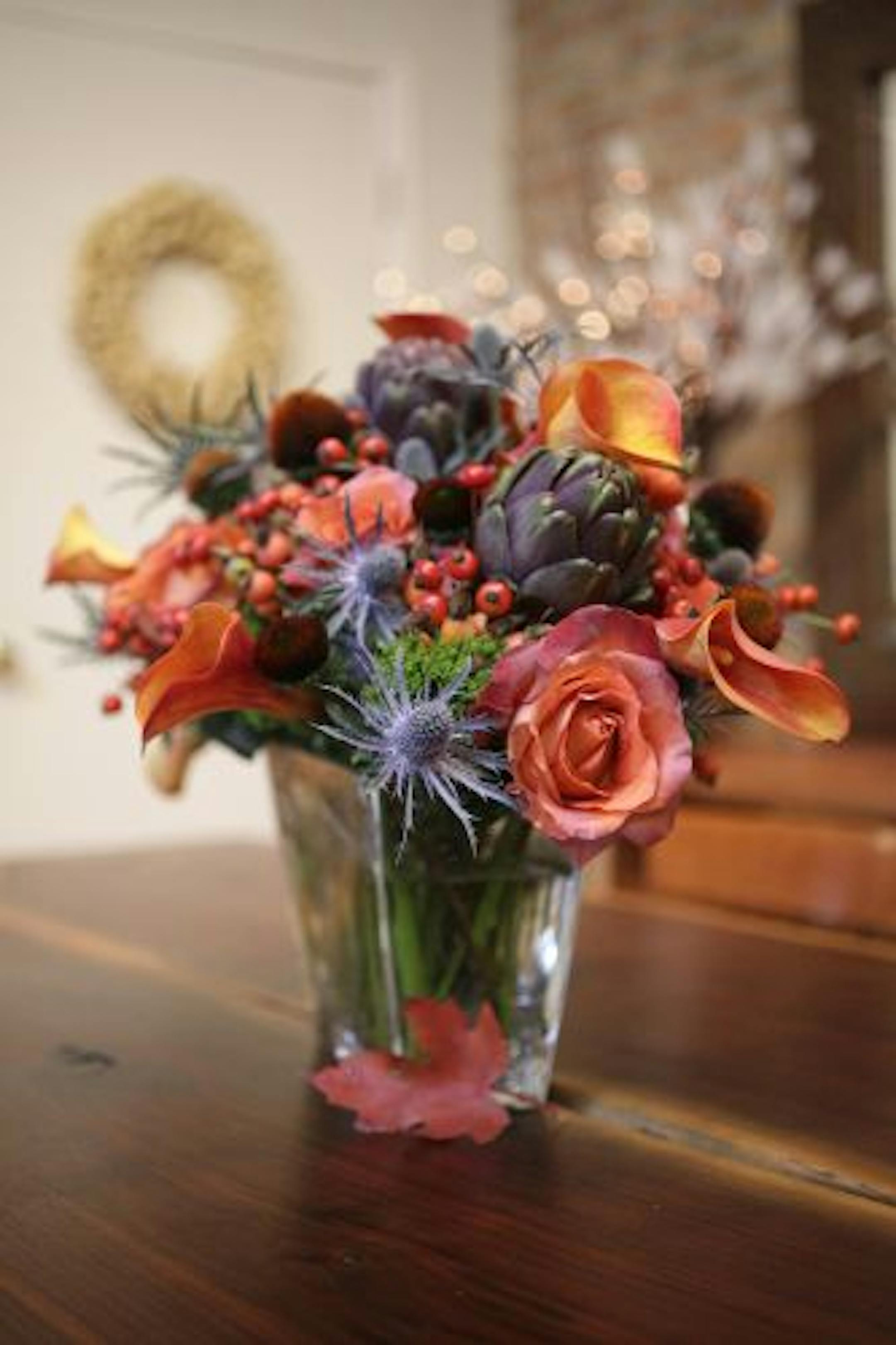 Sea holly, "Coffee Break" rose, calla lilies and cranberry rosehips share a starring role in this bouquet. Dried coneflowers and purple artichokes add additional visual interest.