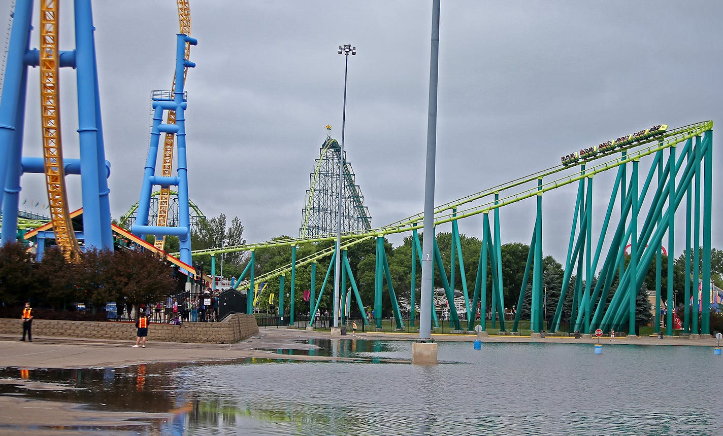 Valleyfair enthusiasts ride a roller coaster near a flooded parking lot, Wednesday, June 25, 2014 in Shakopee, MN. The parking lot and three rides were closed due to flooding; however, the rest of the park remained open. ] (ELIZABETH FLORES/STAR TRIBUNE) ELIZABETH FLORES &#x2022; eflores@startribune.com