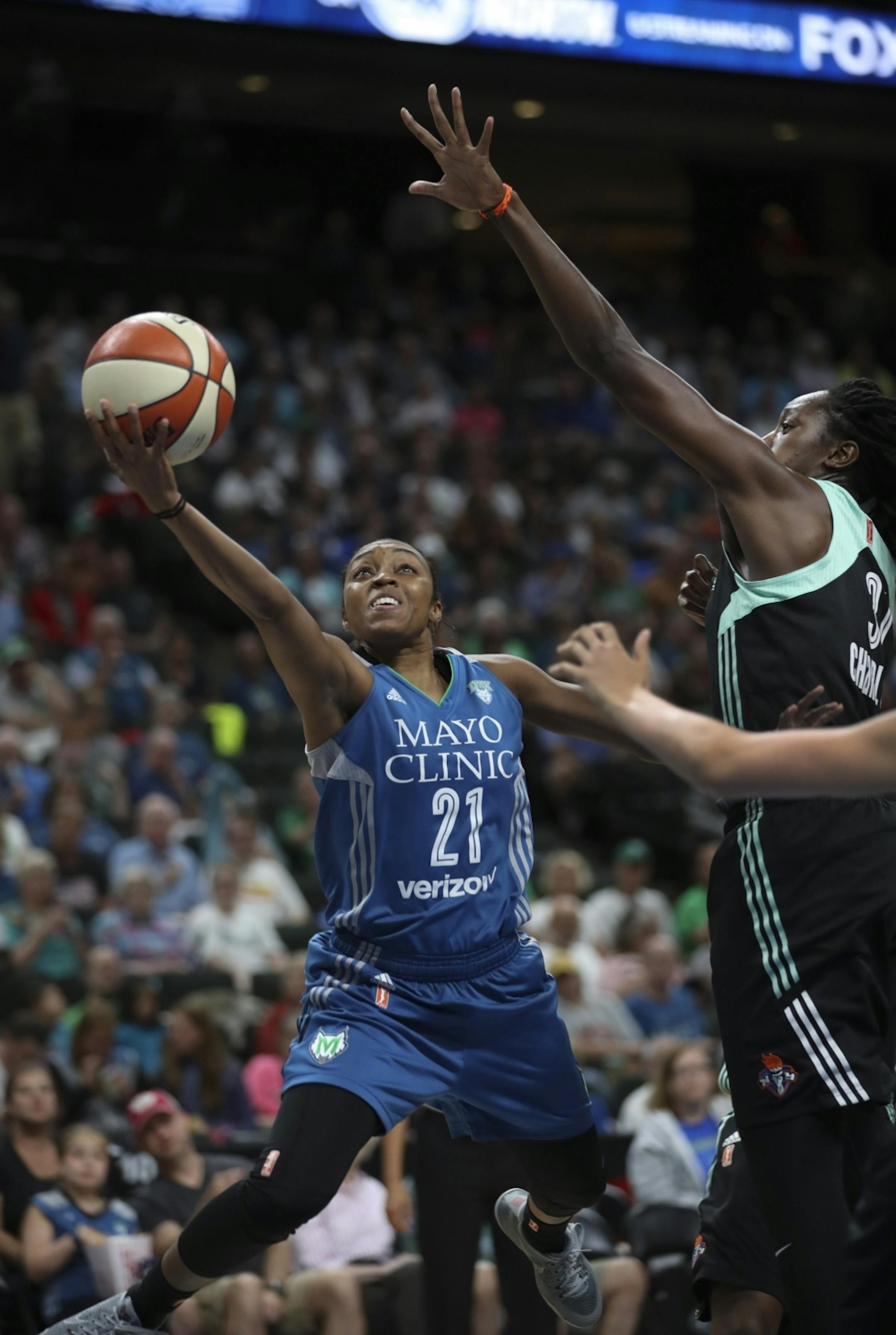Minnesota Lynx guard Renee Montgomery (21) shot under the net and under the defense of New York Liberty center Tina Charles (31) in the first quarter.