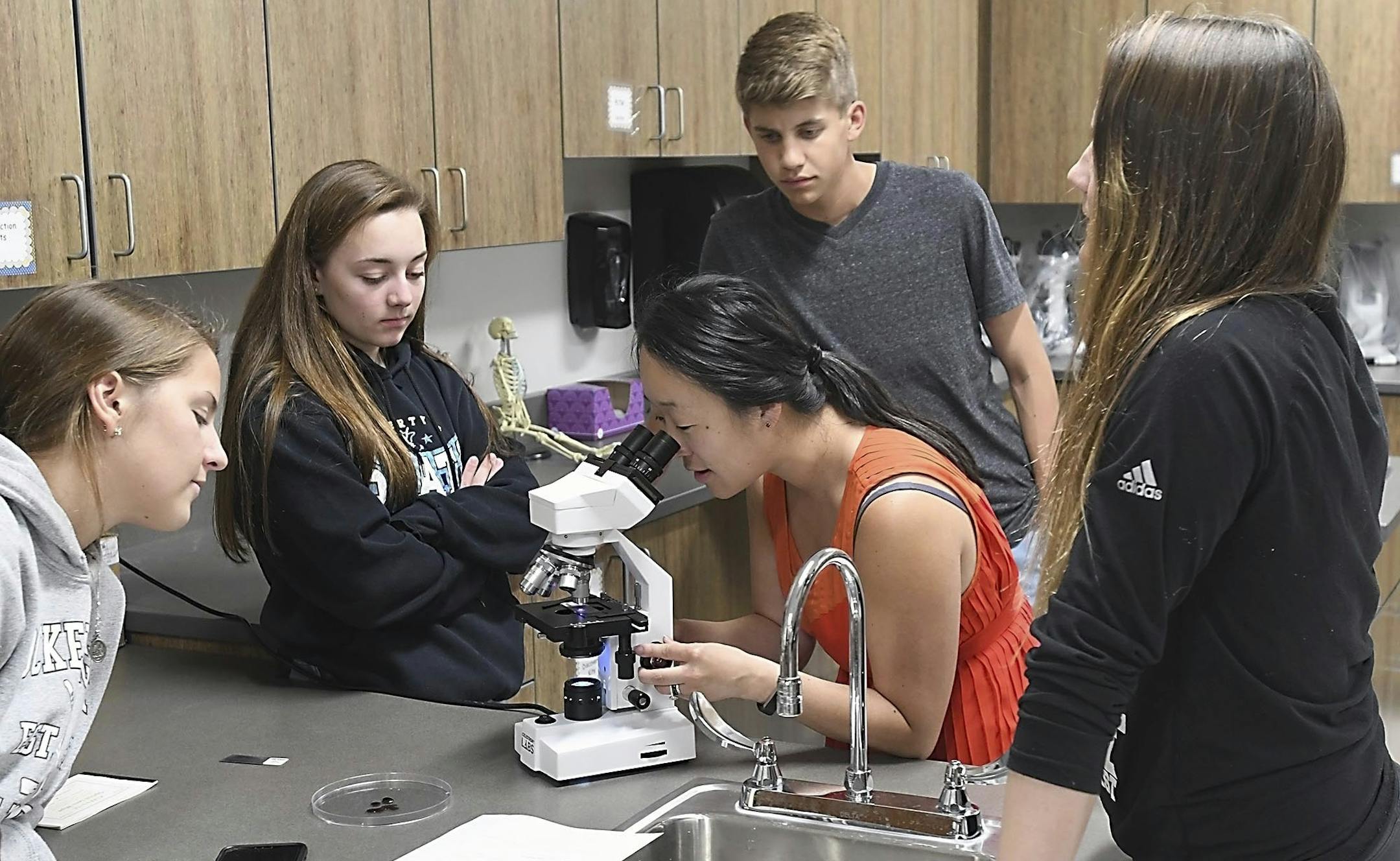 From left, students Andrea Schreiber, Ellie Guillemette, Matthew Wedzina and Haley Stockman watch as teacher Sarah Summers focuses a microscope during a Project Lead the Way biomedical sciences class Wednesday, May 30, 2018, at Mankato East High School. (Pat Christman /The Free Press via AP) ORG XMIT: MNMAN101