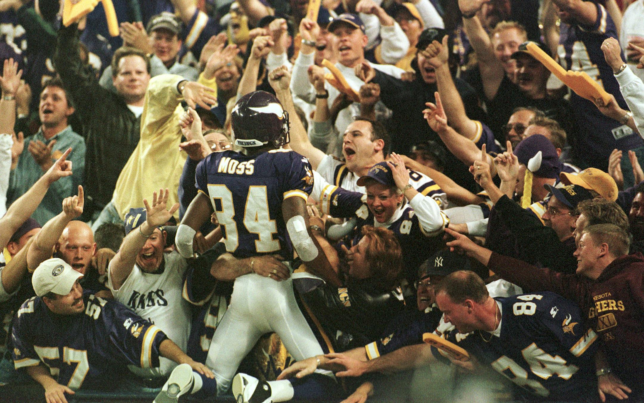 Vikings wide receiver Randy Moss found his way into the end zone and then into the Metrodome crowd after a touchdown catch against Tampa Bay in 2000. Bottom: Moss torched the Packers during his 1998 rookie season. He totaled 13 catches for 343 yards and three scores during his first two games against Green Bay (left and middle). He added three receptions for 163 yards and three TDs against Dallas (right) on Thanksgiving that year.
