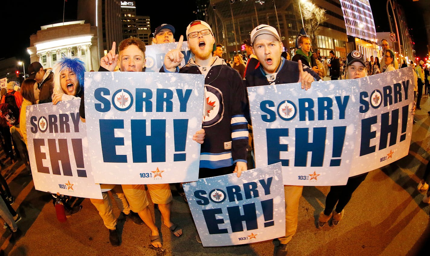 Winnipeg Jet fans celebrate at Portage and Main in downtown Winnipeg, Manitoba, after the Winnipeg Jets defeated the Minnesota Wild 5-0 in Game 5 of an NHL hockey first-round playoff series in Winnipeg, Manitoba, Friday, April 20, 2018. The Jets advanced to the second round. (John Woods/The Canadian Press via AP)