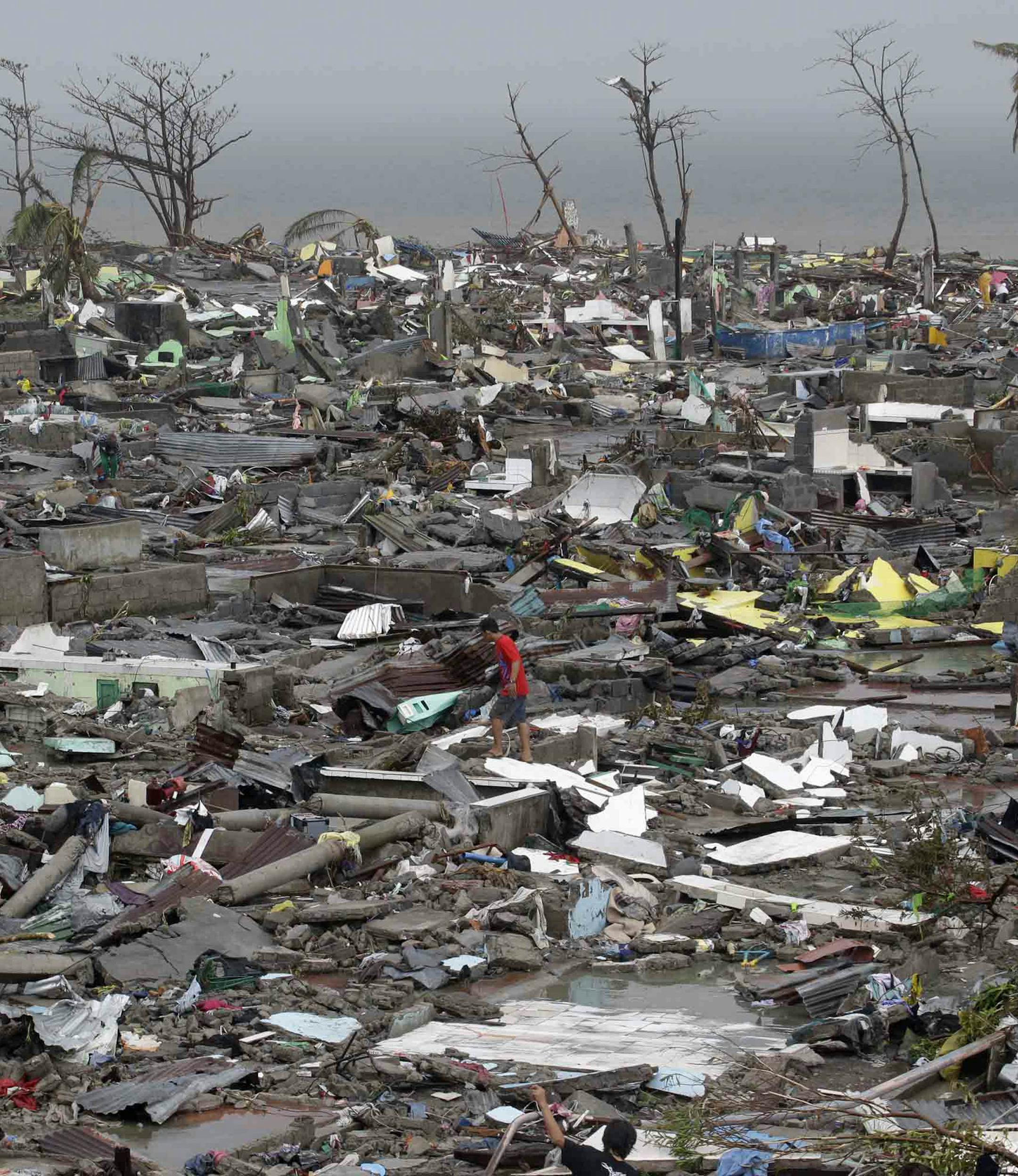 Destroyed houses lie in Tacloban city, Leyte province, central Philippines on Sunday, Nov. 10, 2013. The city remains littered with debris from damaged homes as many complain of shortages of food and water and no electricity since Typhoon Haiyan slammed into their province. Haiyan, one of the most powerful storms on record, slammed into six central Philippine islands on Friday, leaving a wide swath of destruction and scores of people dead. (AP Photo/Bullit Marquez)