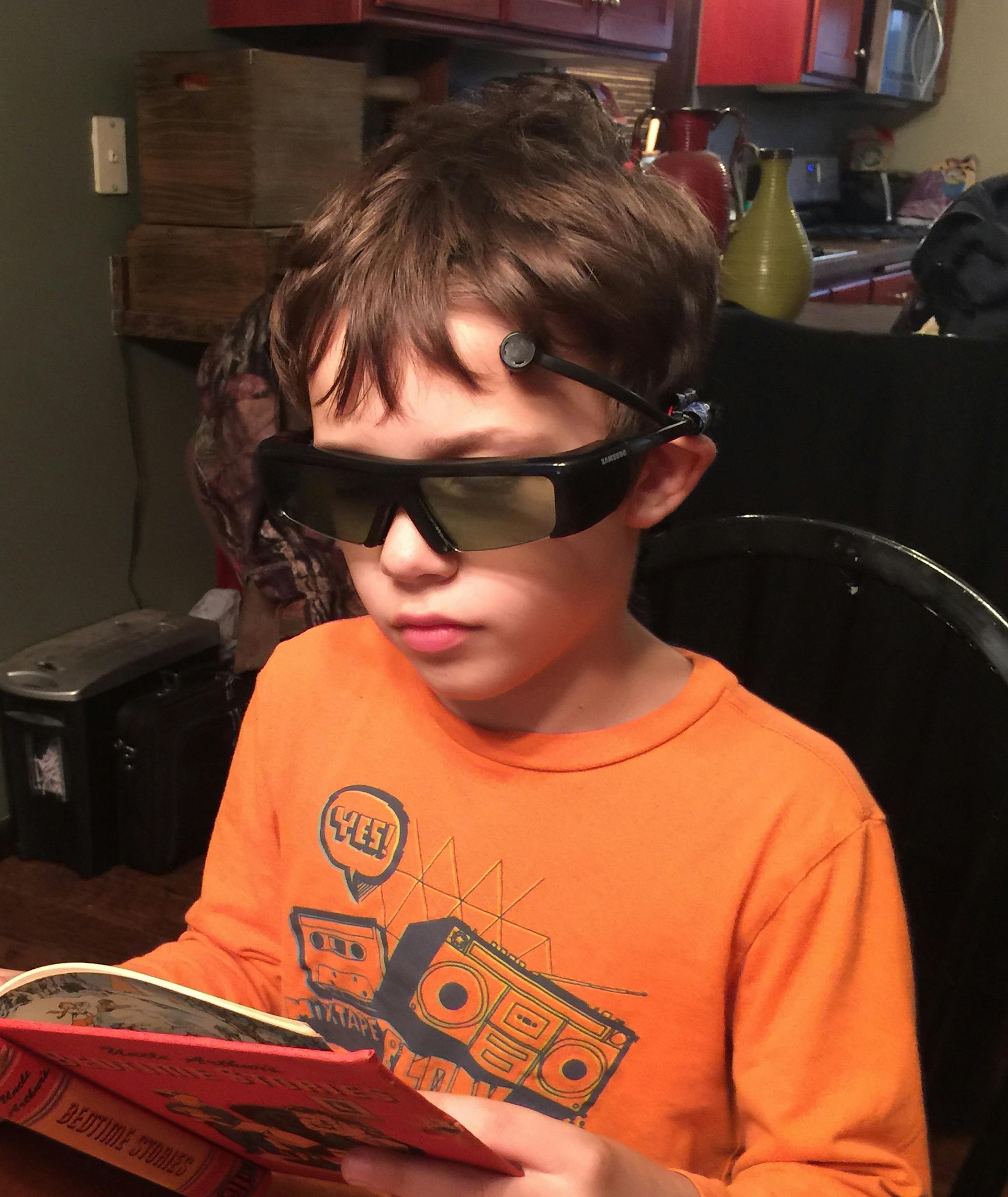 Nine-year-old Jack Anderson, Rod Greder's grandson, reads with the ConfiBoost Eyewear.