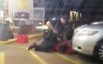 In this Tuesday, July 5, 2016 photo made from video, Alton Sterling is held by two Baton Rouge police officers, with one holding a hand gun, outside a