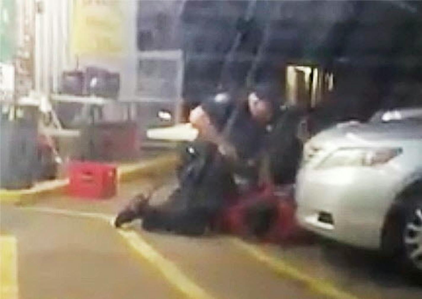 In this Tuesday, July 5, 2016 photo made from video, Alton Sterling is held by two Baton Rouge police officers, with one holding a hand gun, outside a convenience store in Baton Rouge, La. Moments later, one of the officers shot and killed Sterling, a black man who had been selling CDs outside the store, while he was on the ground. (Arthur Reed via AP)