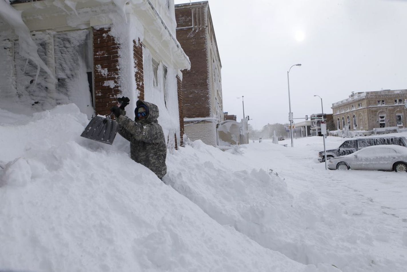 Chad Hoffman clears snow from the entrance to his apartment building in Rapid City, S.D,, Saturday, Oct. 5, 2013. South Dakota emergency agencies are asking snowmobile operators in the Rapid City area to help find motorists stranded by an autumn storm. The National Weather Service says the storm dumped at least three and a half feet of wet, heavy snow in the Black Hills. Rapid City had 21 inches, but 31 inches was recorded just a mile southwest of the city.