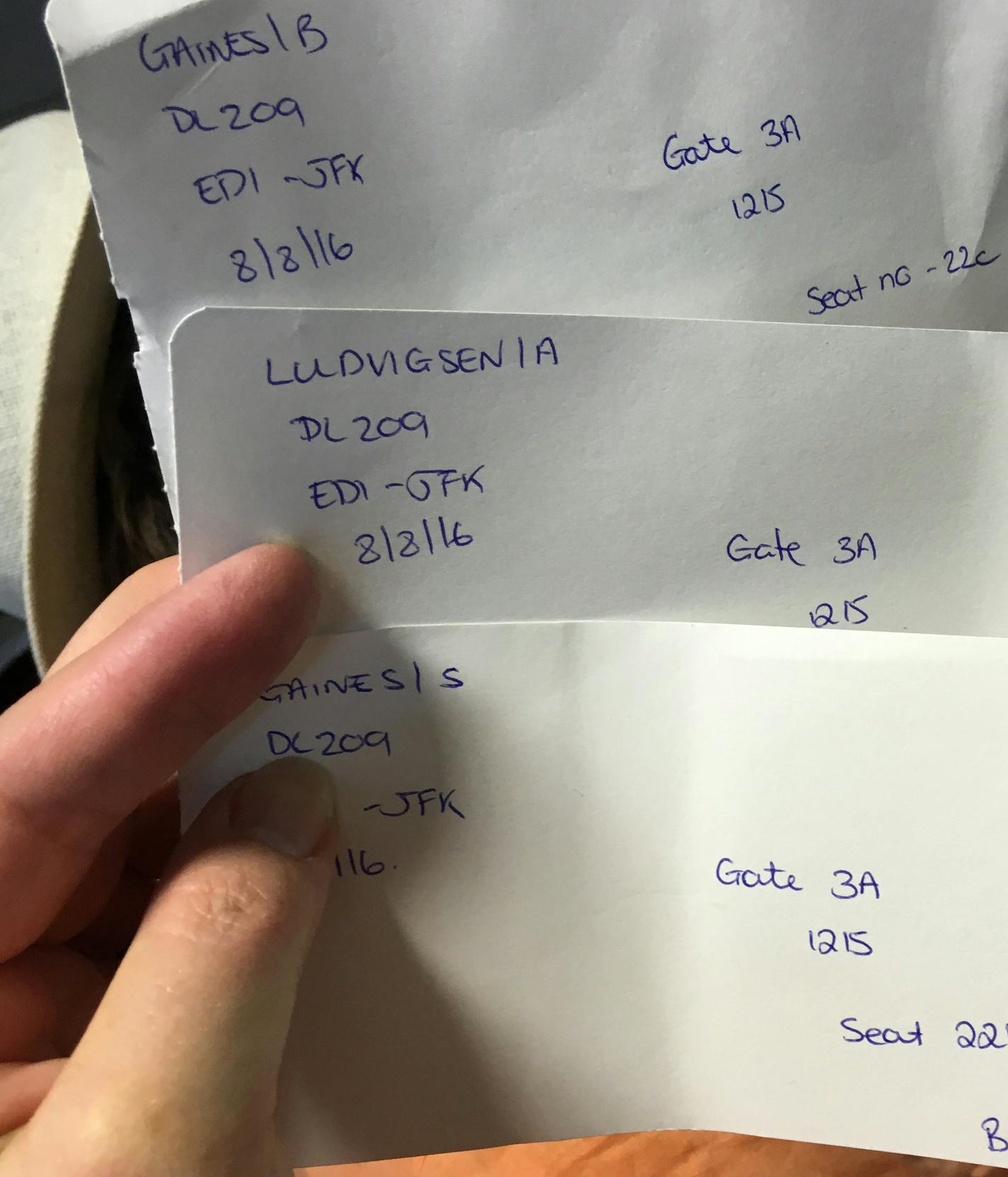 In this photo provided by Barbara Gaines, Gaines holds handwritten boarding passes issued to her by Delta Air Lines, Monday, Aug. 8, 2016, at Edinburgh Airport, in Edinburgh, Scotland, for her trip to New York's John F. Kennedy International Airport. Delta Air Lines delayed or canceled hundreds of flights Monday after its computer systems crashed, stranding thousands of people on a busy travel day. (Barbara Gaines via AP)