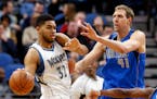 Minnesota Timberwolves' Karl-Anthony Towns, left, keeps the ball away from Dallas Mavericks' Dirk Nowitzki of Germany, during the second half of an NB