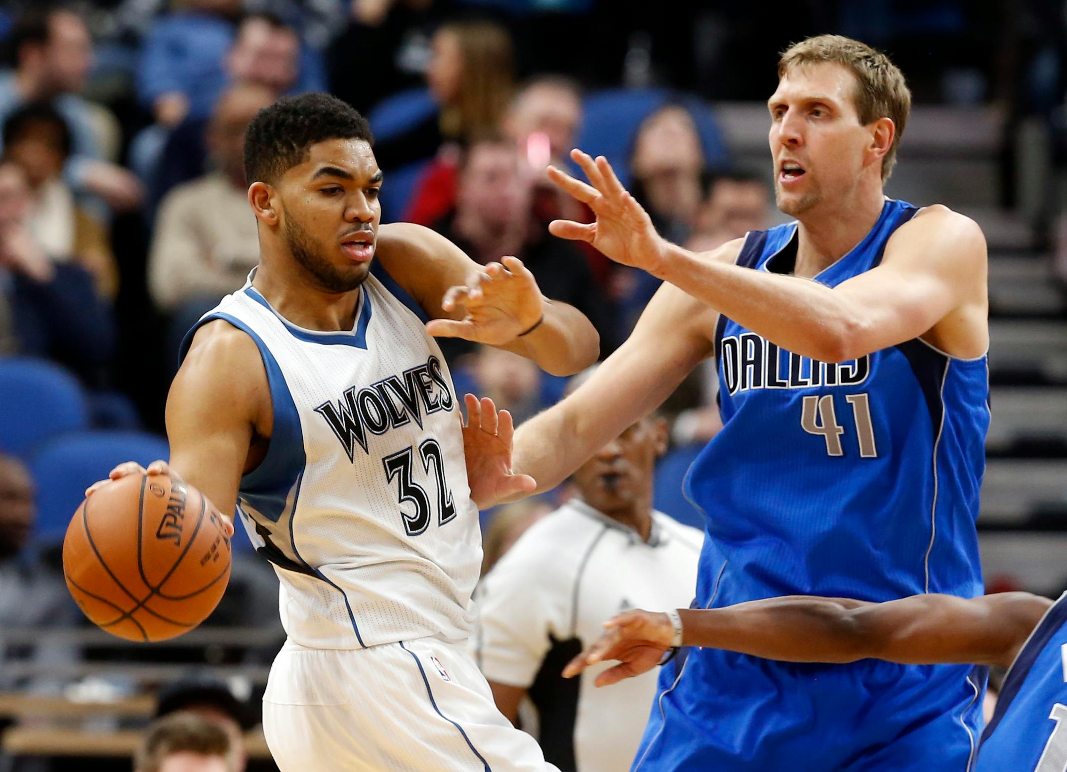 Minnesota Timberwolves' Karl-Anthony Towns, left, keeps the ball away from Dallas Mavericks' Dirk Nowitzki of Germany, during the second half of an NBA basketball game Friday, Feb. 24, 2017, in Minneapolis. (AP Photo/Jim Mone)