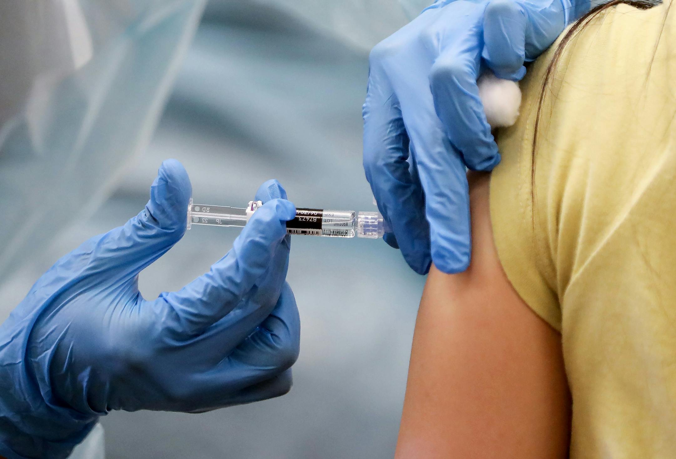 A nurse administers a flu vaccination shot to a woman at a free clinic at a local library on October 14, 2020 in Lakewood, California.