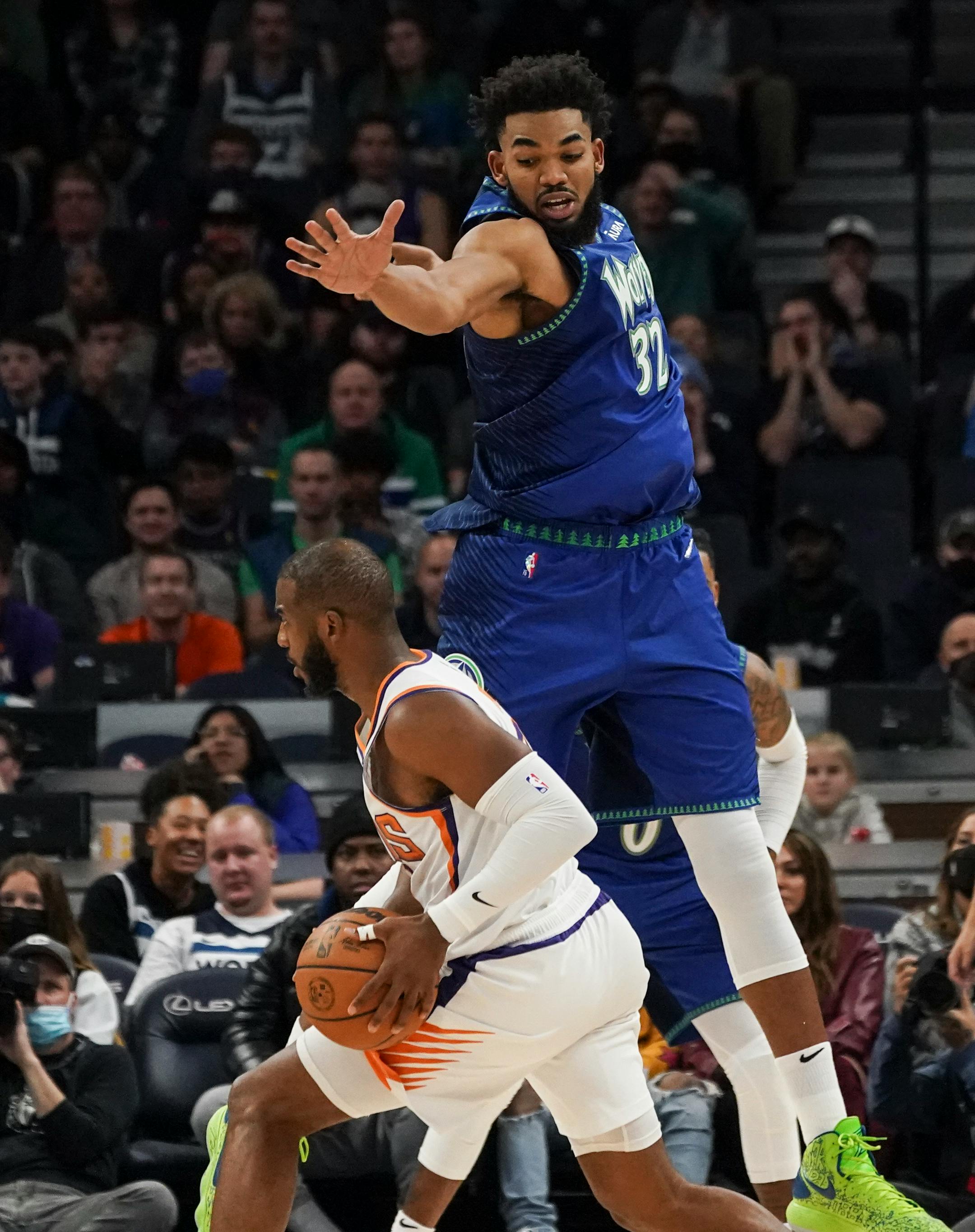 Minnesota Timberwolves center Karl-Anthony Towns (32) leaps above Phoenix Suns guard Chris Paul (3) on defense in the fourth quarter.