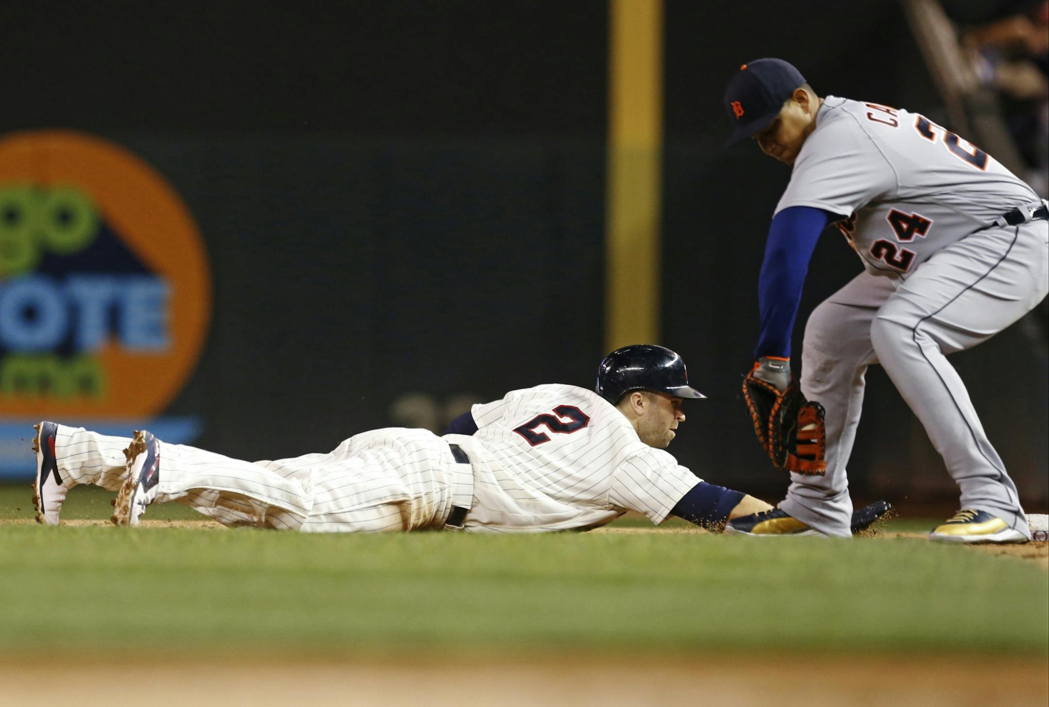 Minnesota Twins' Brian Dozier, left, dives back safely to first to beat the tag by Detroit Tigers first baseman Miguel Cabrera on a pickoff attempt in the third inning of a baseball game Wednesday, Sept. 21, 2016, in Minneapolis.