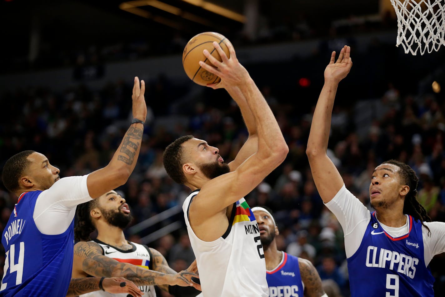 Timberwolves center Rudy Gobert shoots between the Clippers' Moses Brown (9) and Norman Powell (24) during the second half