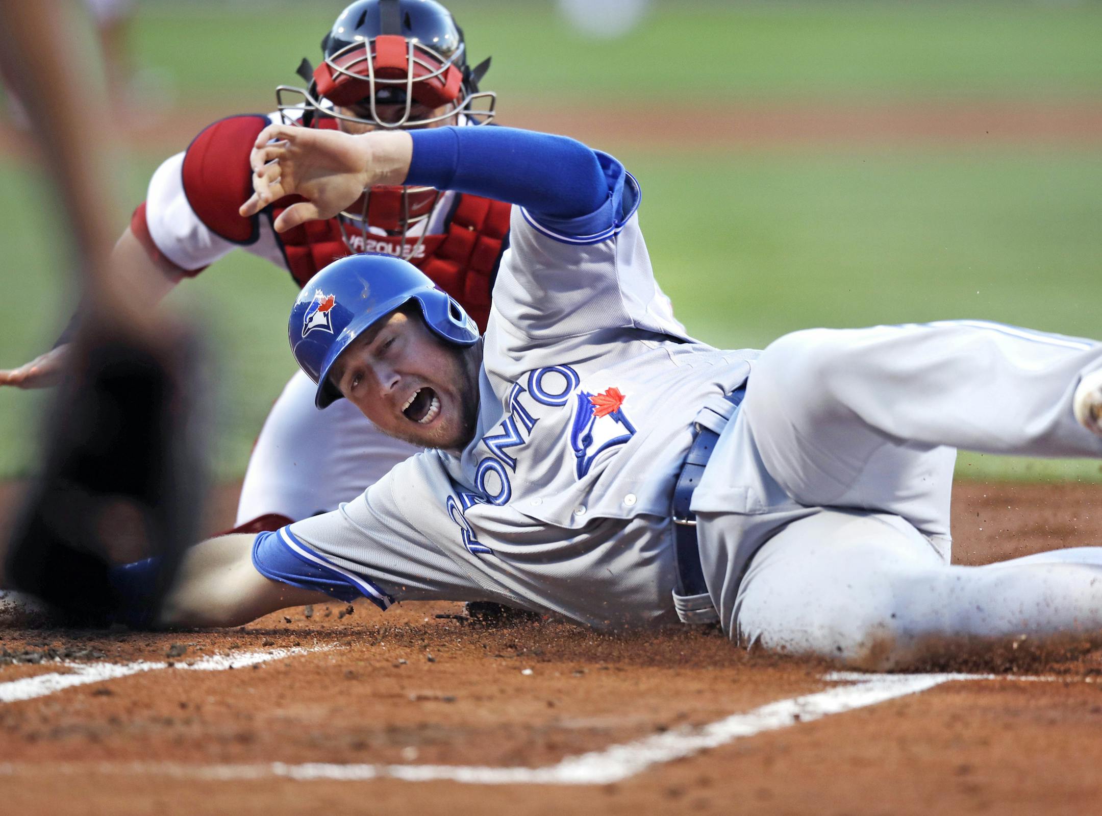 Toronto Blue Jays' Justin Smoak beats the tag by Boston Red Sox catcher Christian Vazquez to score on a two-run double by Kendrys Morales during the first inning of a baseball game at Fenway Park in Boston, Monday, July 17, 2017. (AP Photo/Charles Krupa)