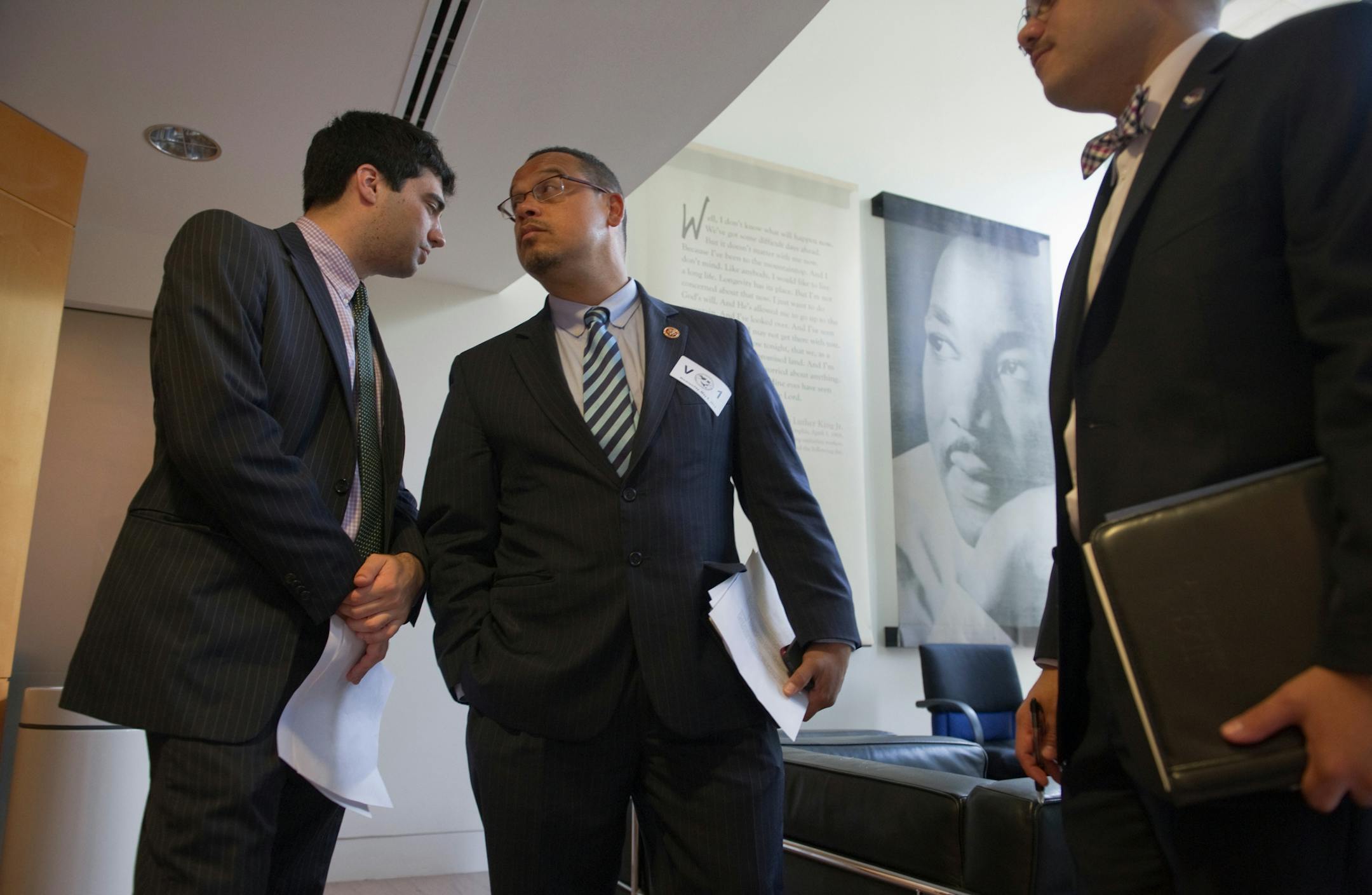 Rep. Keith Ellison, D-MN, middle, listens to an aide from his office before speaking on a panel at the National Youth Economic Policy Forum at the AFL-CIO Washington, D.C. headquarters. 20130508 Photo by Mary F. Calvert