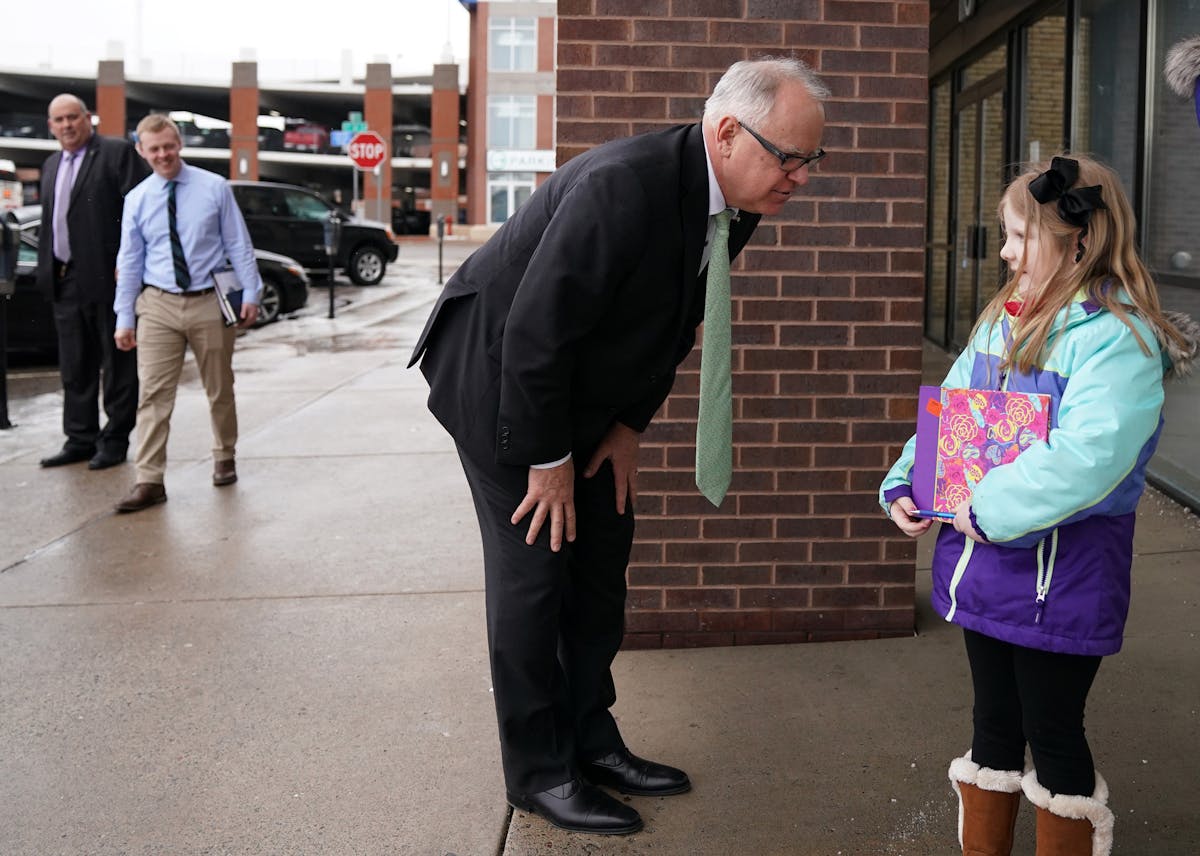 Gov. Tim Walz stopped to greet Alivia Depa, 5, following a round table discussion on health care at the Mid-Minnesota Legal Aid in St. Cloud Thursday.