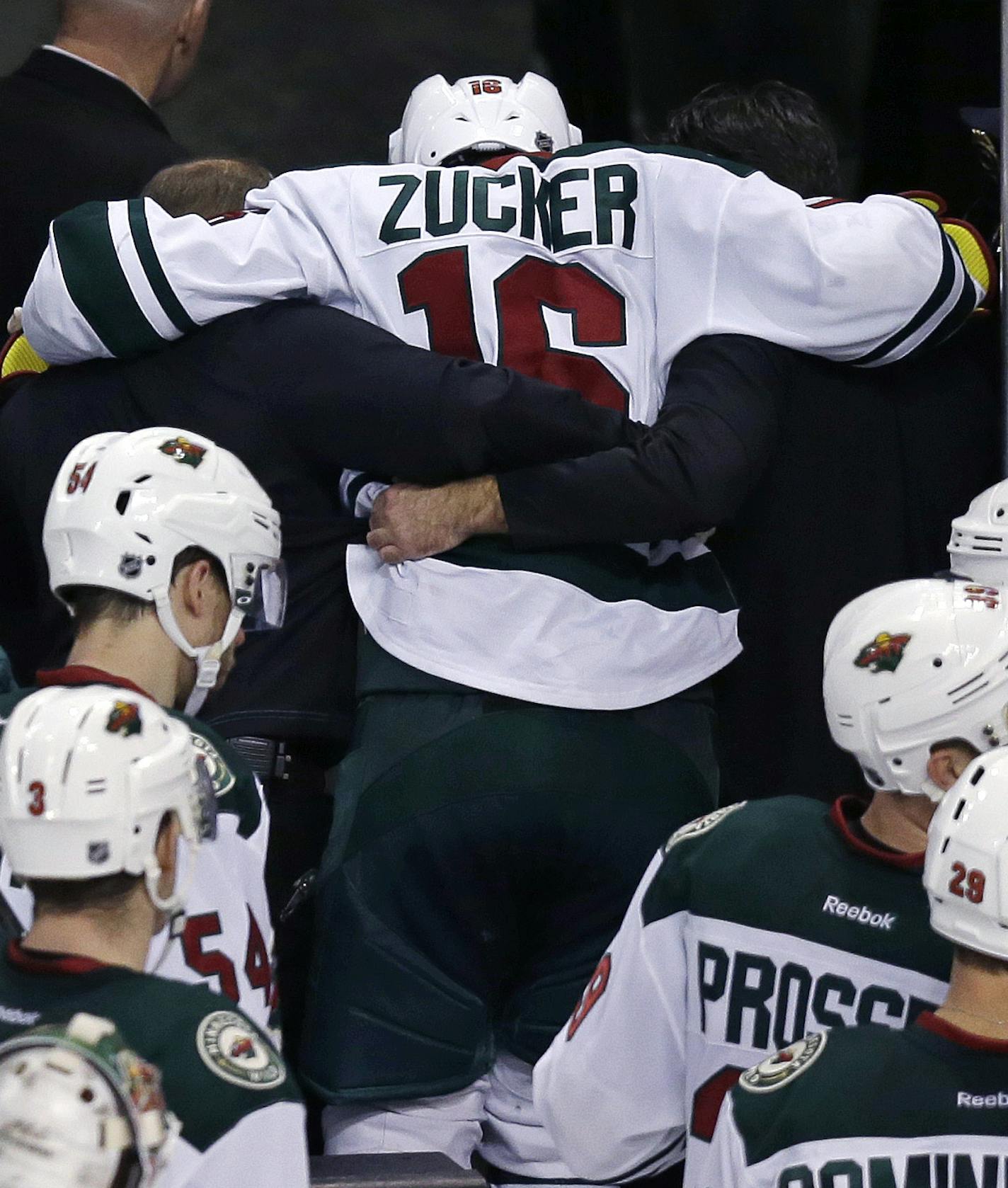 Minnesota Wild left wing Jason Zucker (16) is helped from the ice after an injury in the final seconds of the third period of an NHL hockey game against the Boston Bruins in Boston Thursday, Nov. 19, 2015. (AP Photo/Charles Krupa)