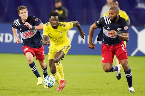 Nashville SC forward Abu Danladi (7) dribbles the ball ahead of New England Revolution's Scott Caldwell, left, and Andrew Farrell, right, during the f