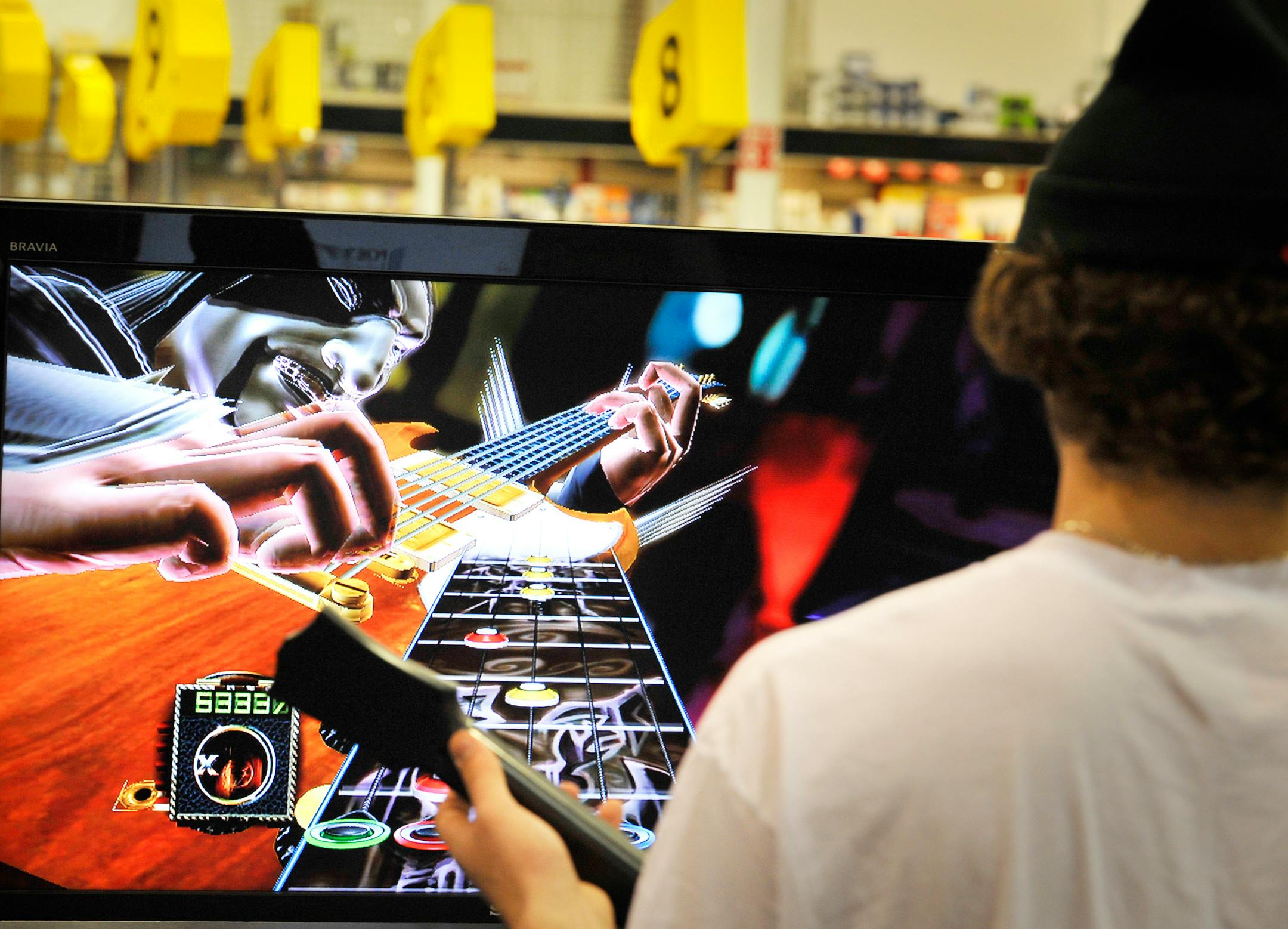 Mike Chacich of Apple Valley tried the "Guitar Hero" display Wednesday at his local Best Buy store, which has expanded its video game area. Best Buy is focusing on its "customer centricity" concept.