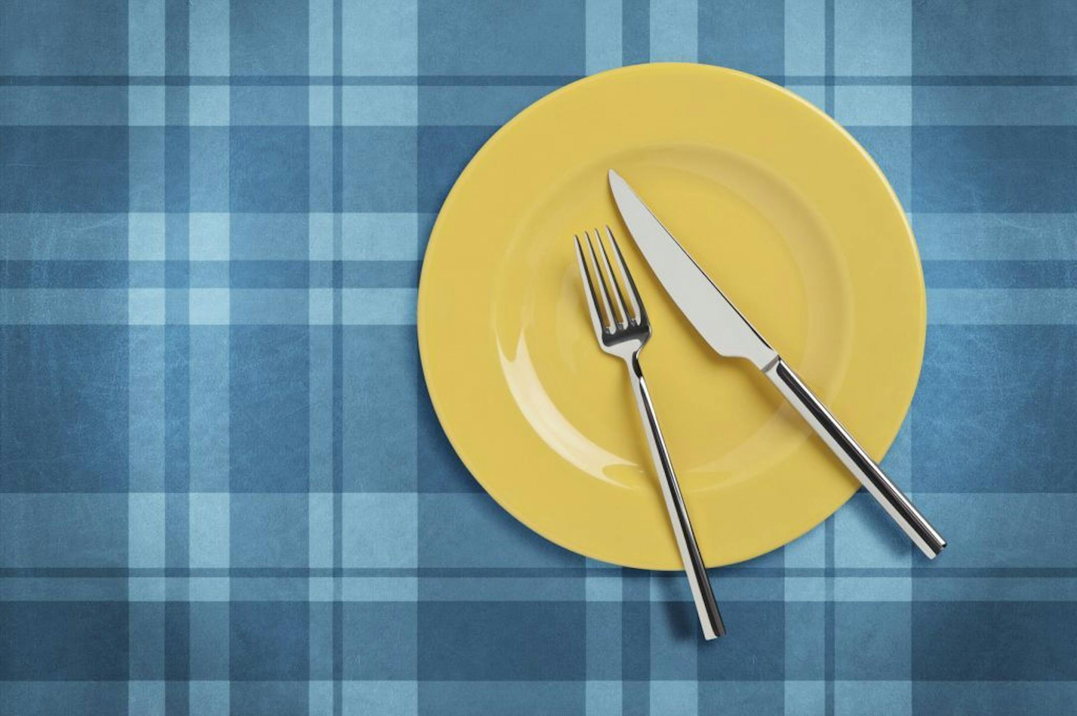 "Empty yellow plate and fork,and table knife on plaid tablecloth. Table setting Include clipping paths.For similar images"