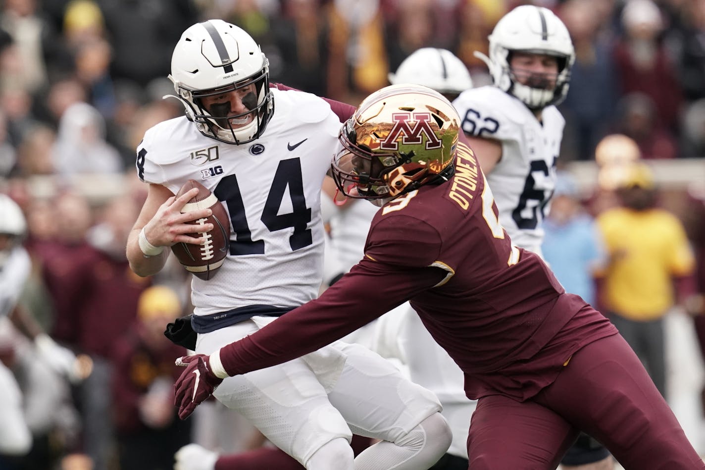 Minnesota Golden Gophers defensive lineman Esezi Otomewo (9) tackled Penn State Nittany Lions quarterback Sean Clifford (14) during a third quarter drive.