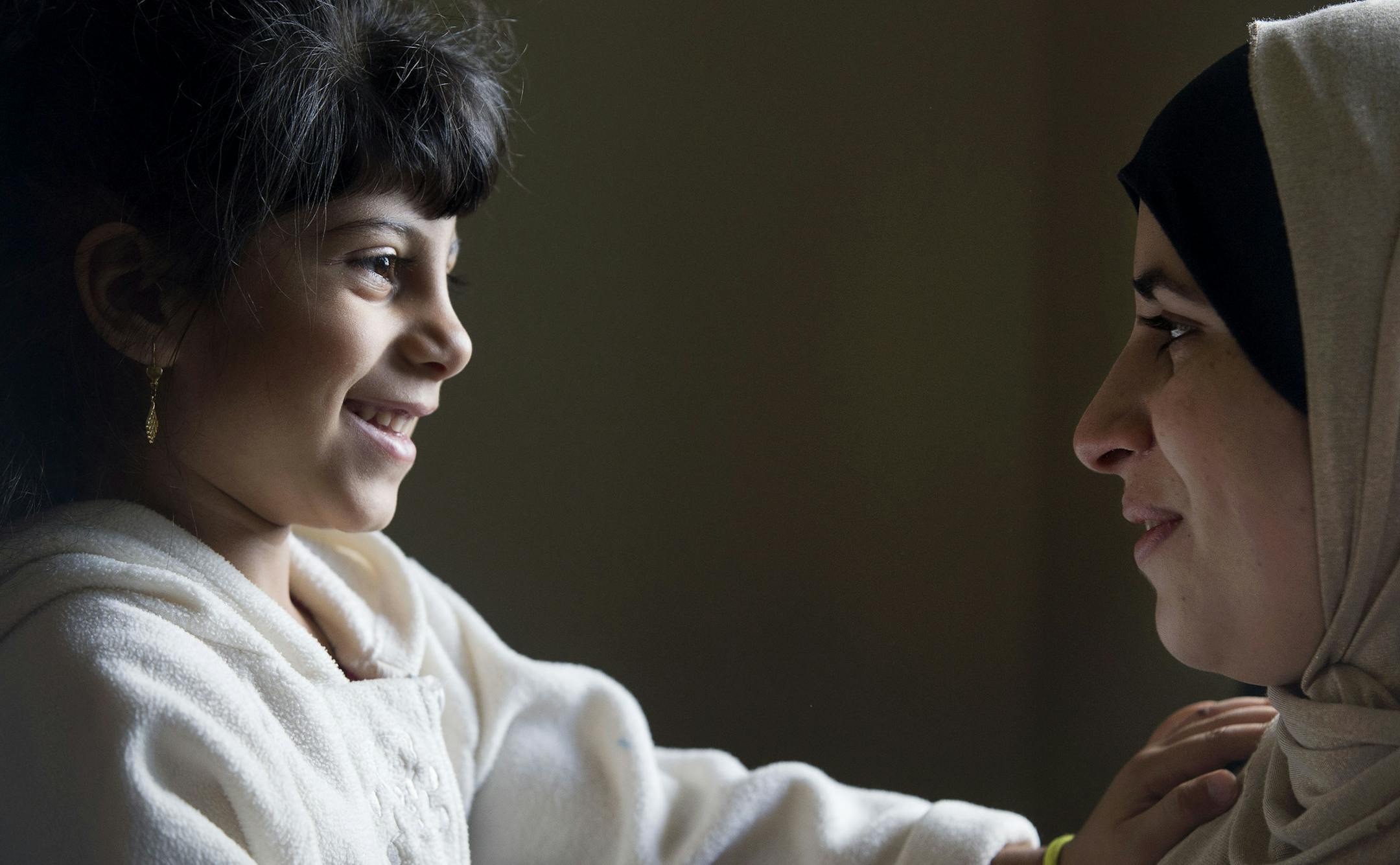 From left, Samar Mohamad Khir Alobeid, 5, smiled at her mother, Ramia Abdulkarim Aljasem, at their home in Rochester, Minn., on Friday September 11, 2015. ] RACHEL WOOLF The family of seven are refugees from Syria that came to Rochester, Minn. in April.