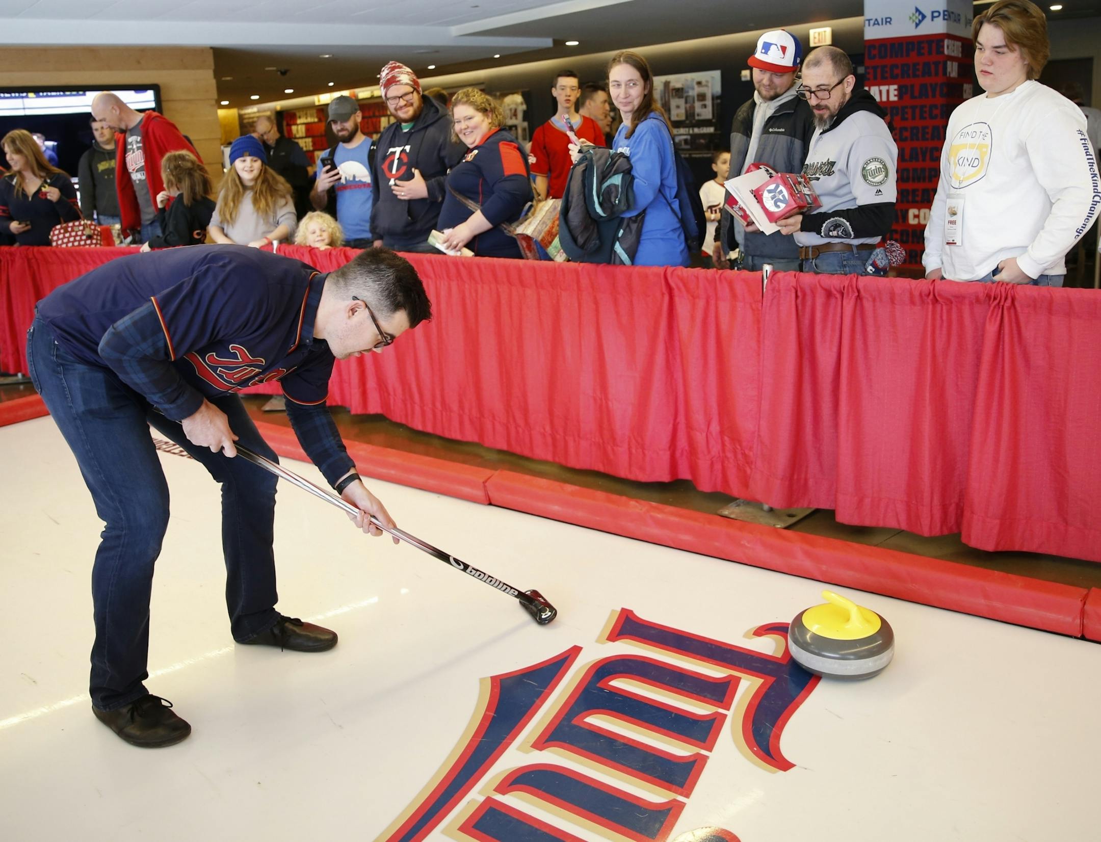 Twins pitcher Trevor May pretended to sweep behind a stone at the street curling booth at TwinsFest.