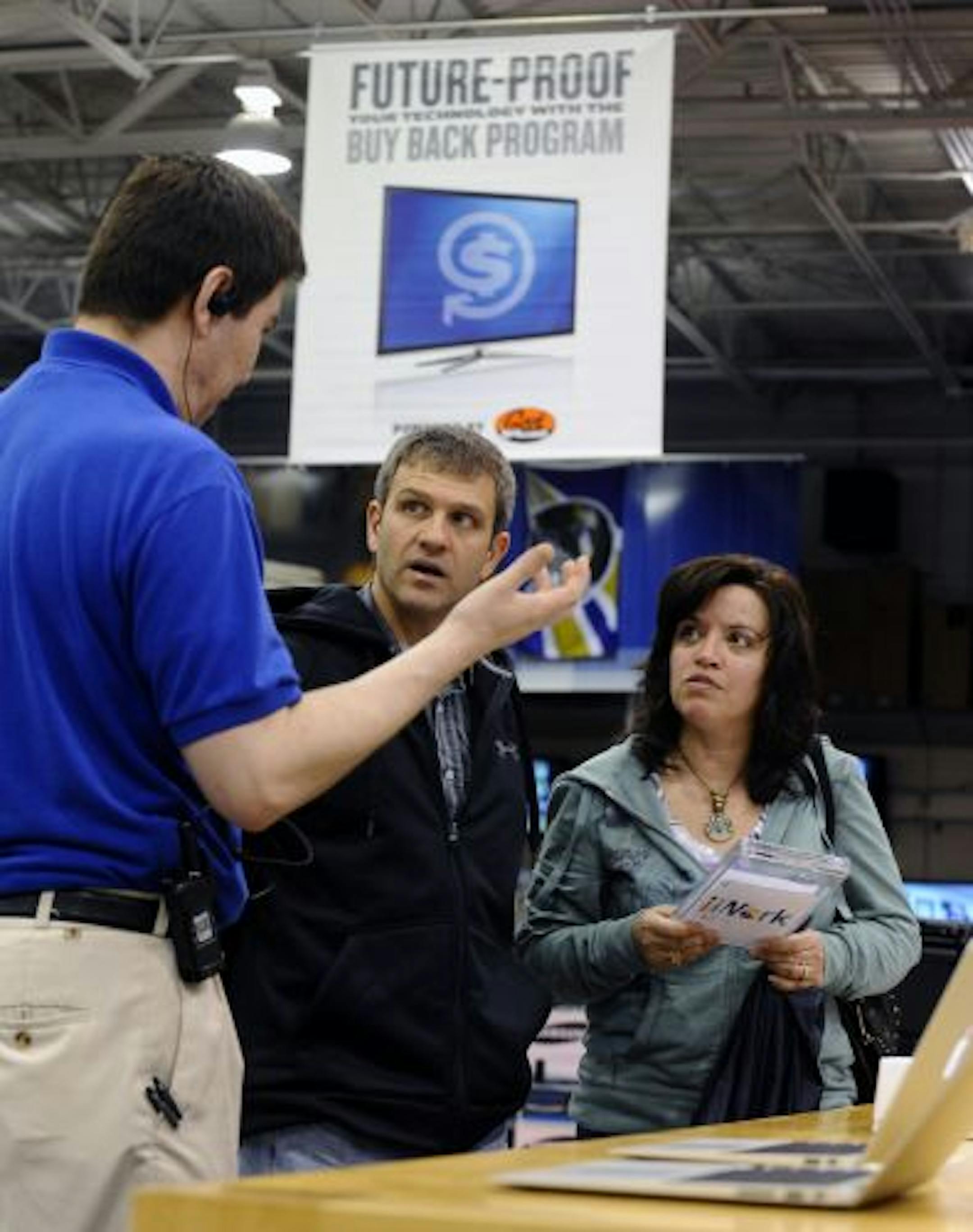 Best Buy employee Rustam Ibragimov, left, explained the company's buyback program to Roger and Robin Wilson, of Frostburg, Md., who were shopping for a laptop computer.