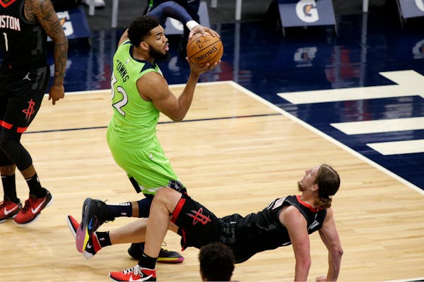 Houston Rockets center Kelly Olynyk (41) tries to take a charge but fouls Minnesota Timberwolves center Karl-Anthony Towns (32) during the first half 